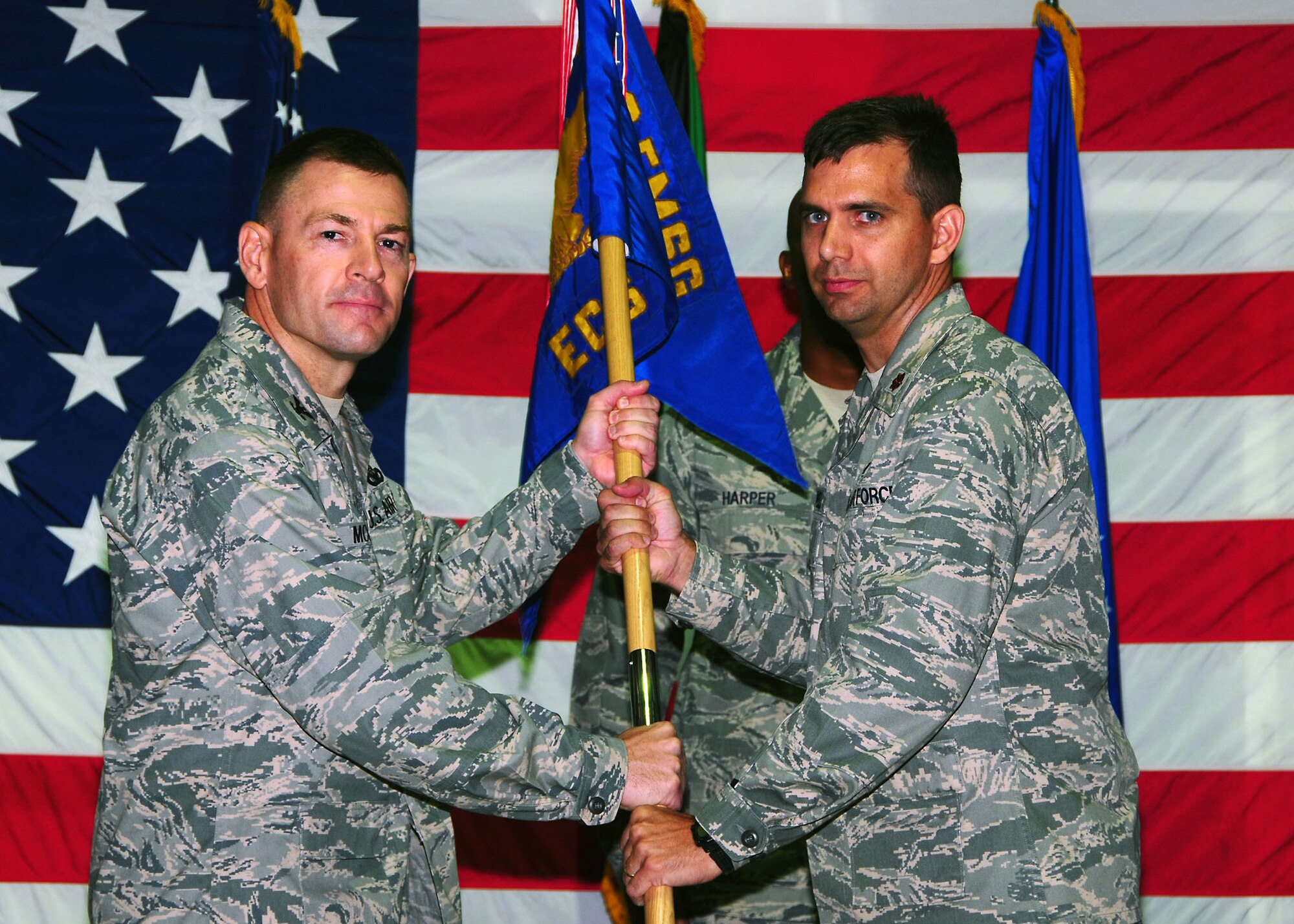 Maj. Roy Rockwell, right, assumes command of the 386th Expeditionary Communications Squadron, by accepting the guidon from Col. Richard McComb, 386th Expeditionary Mission Support Group commander, during a change of command ceremony in Southwest Asia July 9.  (U.S. Air Force photo/Tech Sgt. Tony Tolley)