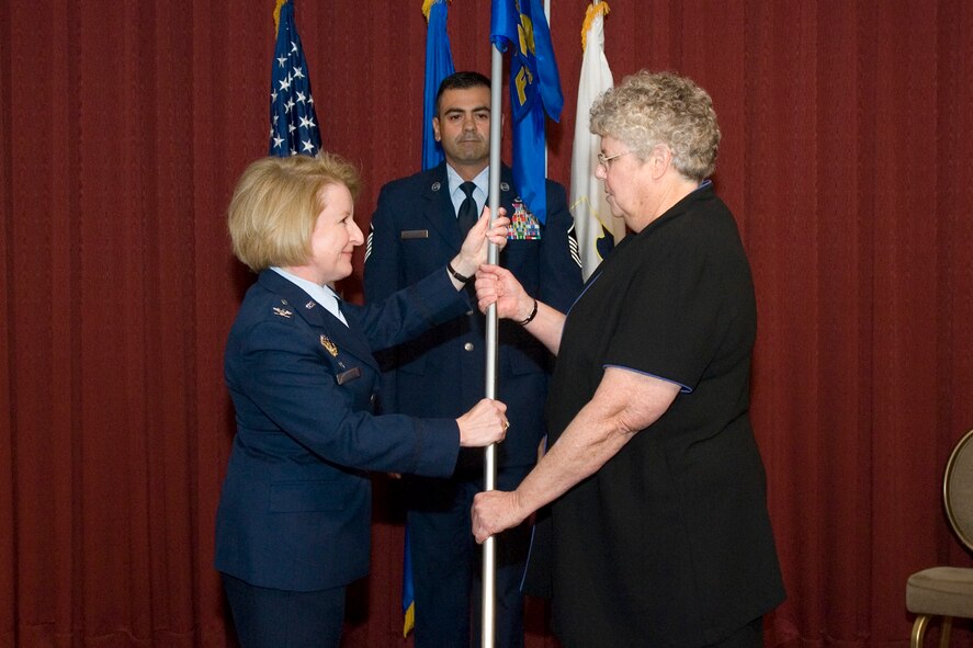 HANSCOM AIR FORCE BASE, Mass. - Ms. Nanci Wildman, new 66th Force Support Squadron director, assumes command of the newly activated squadron from Col. Deborah Van De Ven, 66th Mission Support Group commander, as Master Sgt. Donald Gonsalves awaits the guidon to post. During the July 7 ceremony, Hanscom officially stood up it's new 66th Force Support Squadron. (Air Force photo by Rick Berry) 