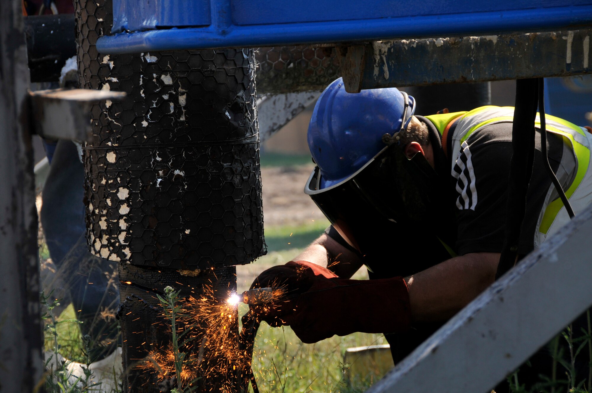 Greg Ashcroft, Land and Marine Project Engineering demolition operative, removes material from the base of a water tower at RAF Lakenheath July 2, 2009. Two water towers, one of which was more than 40 years old, were removed after a recent installment of a reservoir pump system significantly improved RAF Lakenheath's water system. (U.S. Air Force photo by Tech. Sgt. Chris Stagner)