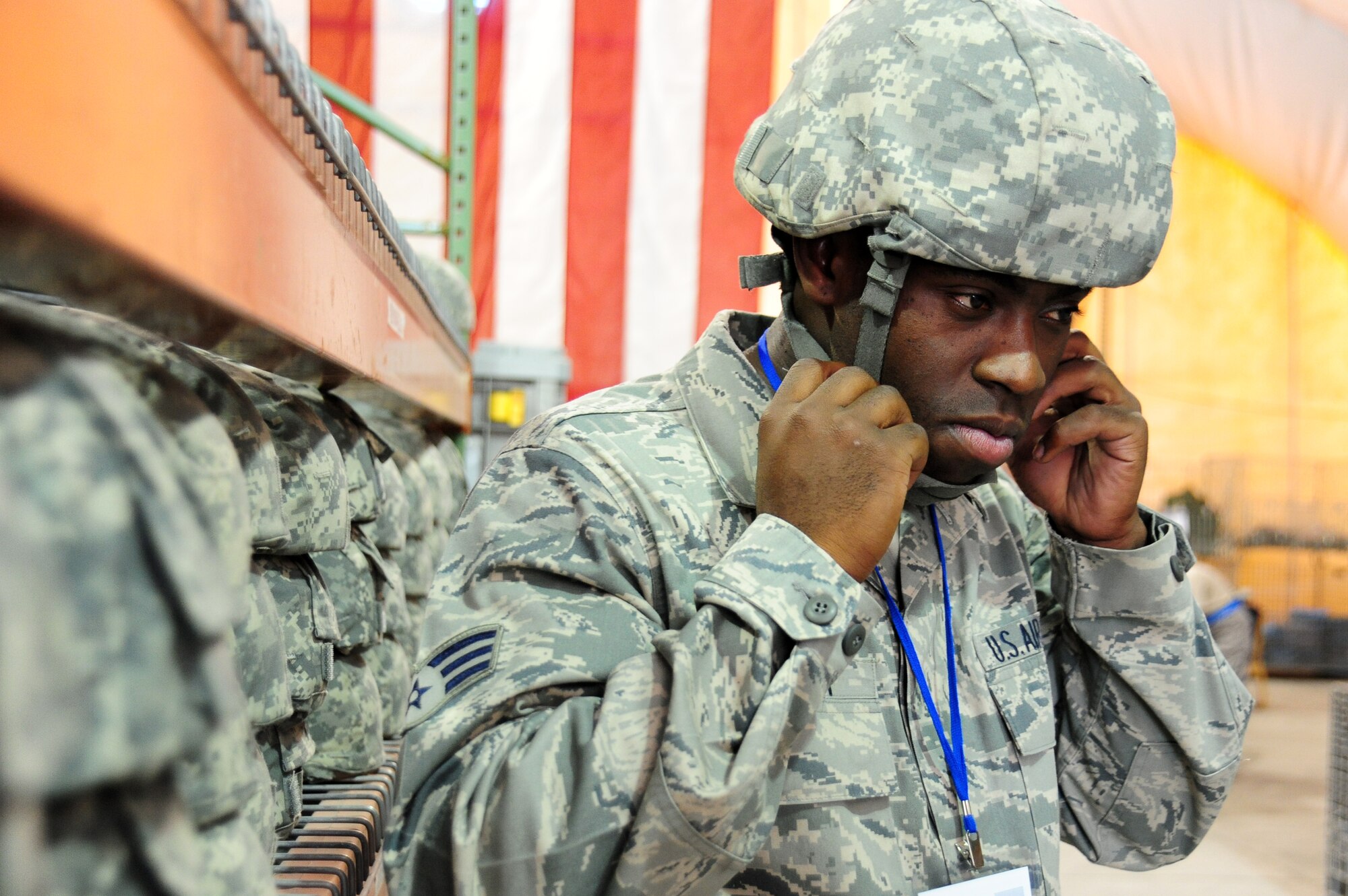Senior Airman Rennison Abraham, 451st Expeditionary Logistics Readiness Squadron, tries on protective headgear at the Expeditionary Theater Distribution Center at Manas Air Base, Kyrgyzstan. Airman Abraham is a fire truck vehicle technician and will be en route to Kandahar AB, Afghanistan. He is deployed from the 99th LRS at Nellis Air Force Base, Nev. Airman Abraham is originally from Los Angeles, Calif., and is deploying in support of Operation ENDURING FREEDOM. (U.S. Air Force photo/Senior Airman Steele Britton)