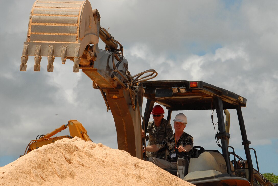 Airman 1st Class Kendal Allen, 554th RED HORSE Squadron, provides instructions as Pactrick Doyle, President and Publisher of Anchorage Daily News, Alaska, operates a backhoe June 26.  Civic leaders from Guam, Hawaii and Alaska toured Andersen Air Force Base, Guam, Elmendorf and Eielson AFBs, Alaska, and Hickam AFB, Hawaii, during a five day regional tour covering 10,000 miles to show the group how Air Force base contributes to the Pacific theater. The Strategic Triangle Civic Leadership tour was hosted by Gen. Howie Chandler, Pacific Air Forces commander.  (U.S. Air Force photo by Senior Airman Nichelle Griffiths/36th Wing Public Affairs)