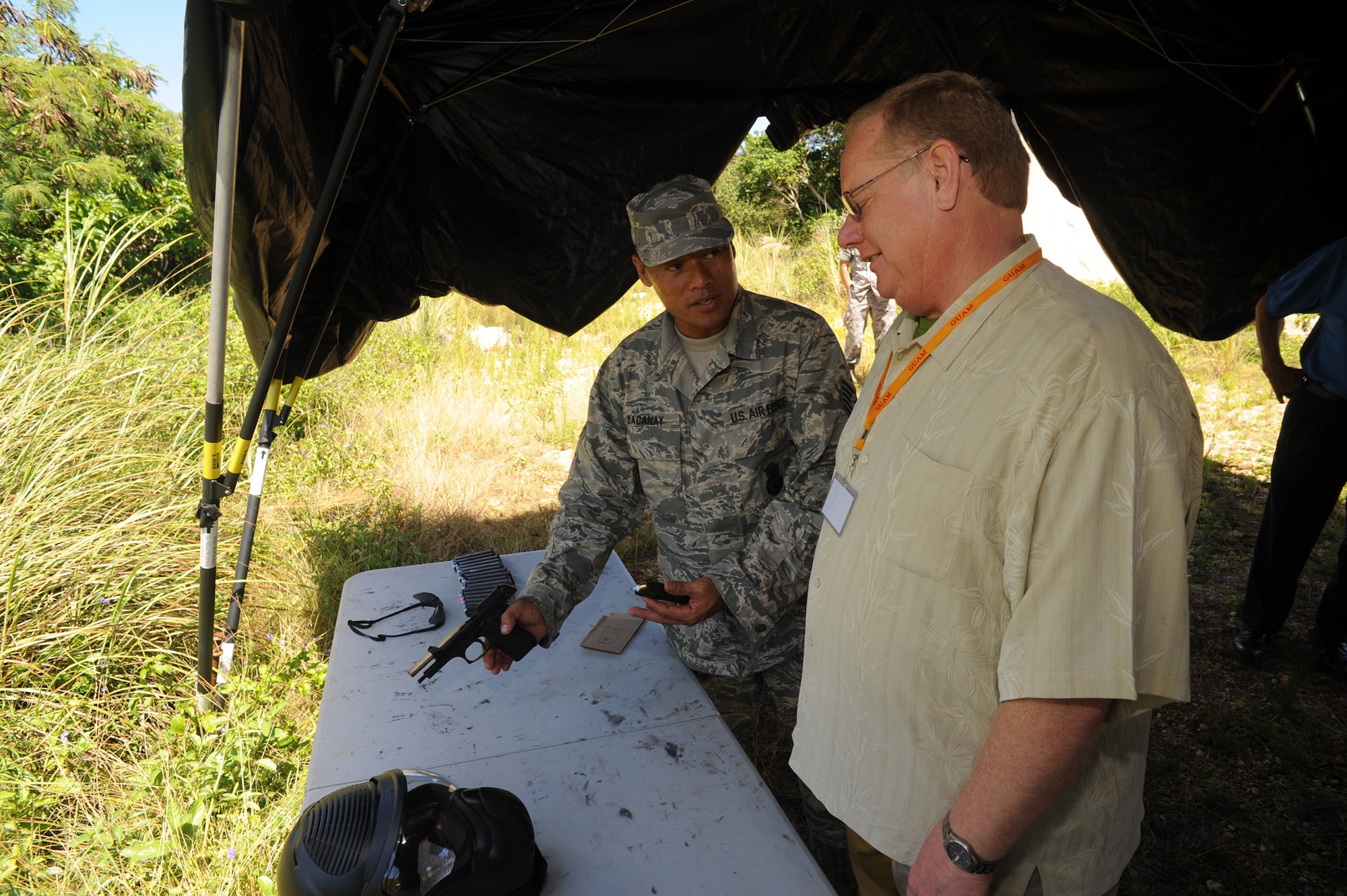 ANDERSEN AIR FORCE BASE, Guam - Tech. Sgt. Robert Dacanay, 736th Security Forces Squadron, shows Terry Parks, Managing partner of Alaska Aces, Alaska, how to load a 9 millimeter pistol during the Strategic Triangle Civic Leader Tour June 26.  Twenty two regional civic leaders visited Guam, Hawaii and Alaska while learning how Air Force bases in the three locations contribute to the Pacific theater.  The Strategic Triangle Civic Leadership tour was hosted by Gen. Howie Chandler, Pacific Air Forces commander. (U.S. Air Force photo by Tech. Sgt. Michael Boquette/36th Wing Public Affairs)