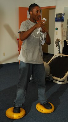 ANDERSEN AIR FORCE BASE, Guam - Jordan Walker, a summer hire for the physical therapy clinic, uses yellow inflatable discs beneath his feet while boxing during a simulated "Wii-hab" warmup session here July 1. Therapy technicians use the discs to help patients work on their balance during exercises in order to make it more challenging. (U.S. Air Force photo by Senior Airman Shane Dunaway)