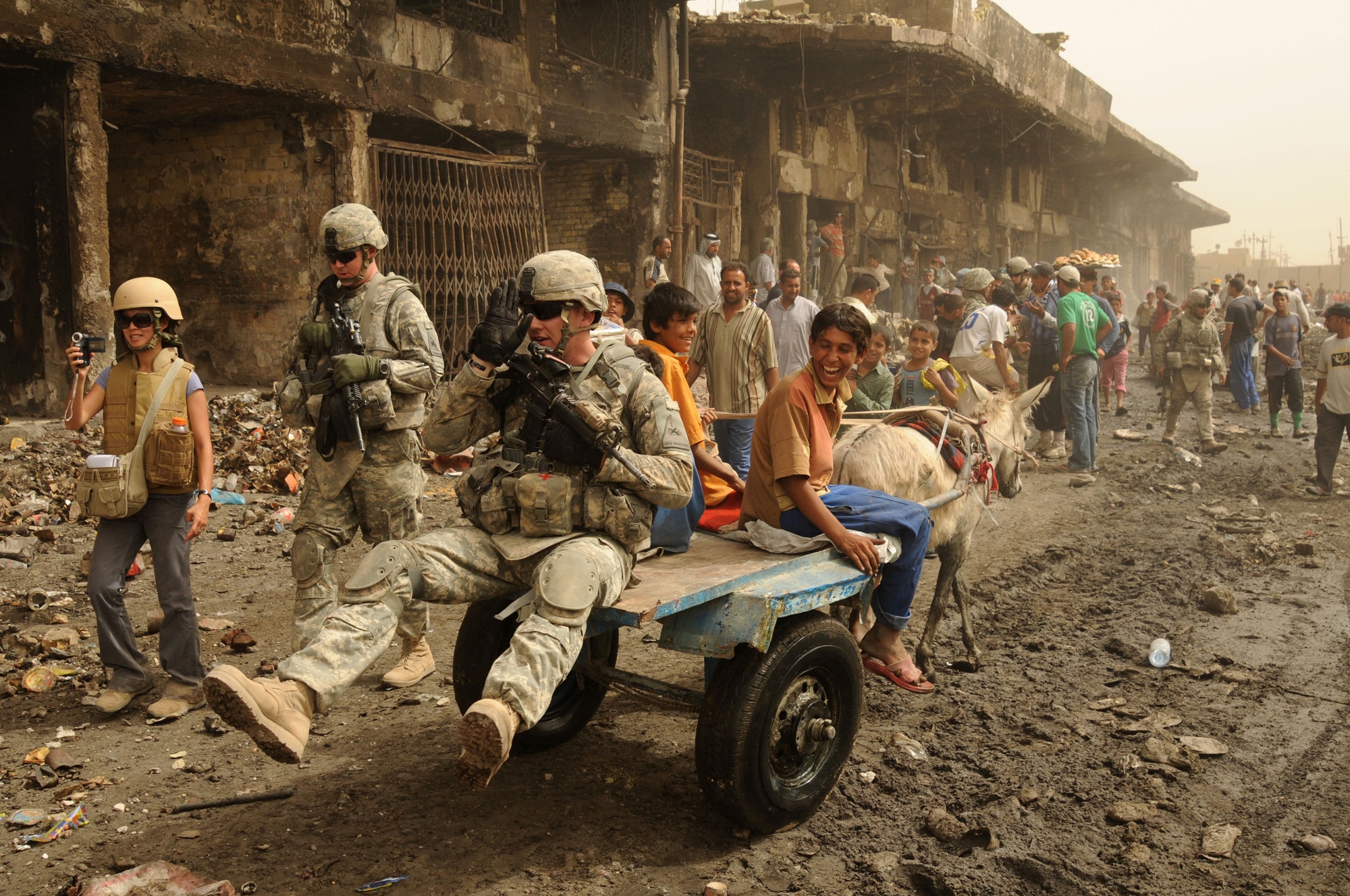 A U.S. Army Soldier from the Task Force Regulars 1st Brigade, 6th Infantry gets a lift from an Iraqi boy and his mule on route Douglas in the Jameela Market area on May 31, 2008.