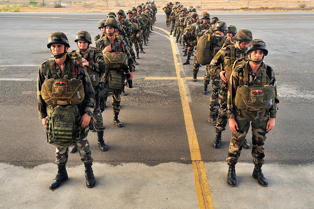 U.S. airmen and French legionnaires wait to board a French C-130 Transall aircraft on a French military base in Djibouti, June 30, 2009.