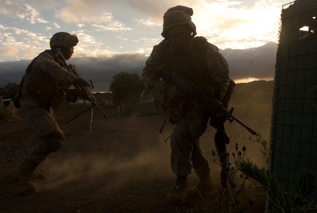 Pfc. Ryan Rasmussen provides security as Lance Cpl. Jeremiah Gott sprints around a corner.