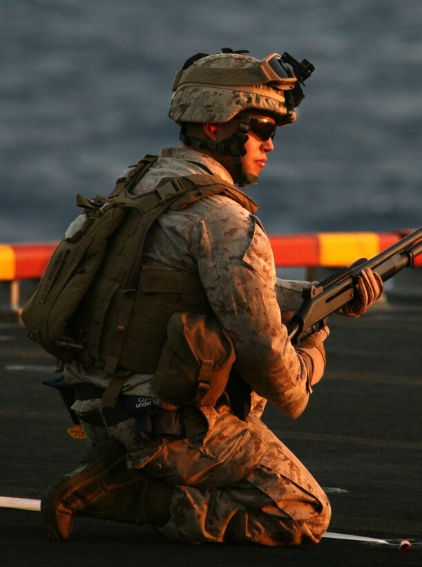 Cpl. Jack R. Masden, a Seattle native and truck driver with Headquarters and Support Company, Battalion Landing Team, 3rd Battalion, 2nd Marine Regiment, 22nd Marine Expeditionary Unit, stands by on the firing line during an M1014 shotgun shoot on the flight deck of multi-purpose amphibious assault ship USS Bataan (LHD 5) July 9, 2009. The 22nd MEU, embarked aboard the ships of the Bataan Amphibious Ready Group, is currently serving as the theater reserve force for U.S. Central Command.::r::::n::(Official Marine Corps photo by Cpl. Theodore W. Ritchie)::r::::n::