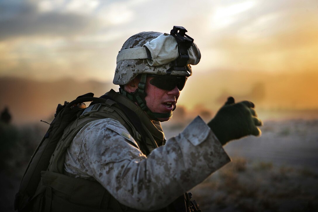 A Marine with Company E signals members of his squad toward a helicopter that will extract his platoon from their position during a long-range helicopter raid at Twentynine Palms, Calif., July 8. The company – one of four that make up Battalion Landing Team 2/4, the 11th Marine Expeditionary Unit’s ground combat element – departed USS Bonhomme Richard in six CH-46s, two CH-53s and other aircraft. The MEU, part of the Bonhomme Richard Amphibious Ready Group, is conducting its first pre-deployment exercise at sea with its Navy counterpart, Amphibious Squadron 7. This Navy and Marine Corps team is testing interoperability before a deployment certification exercise later this summer.