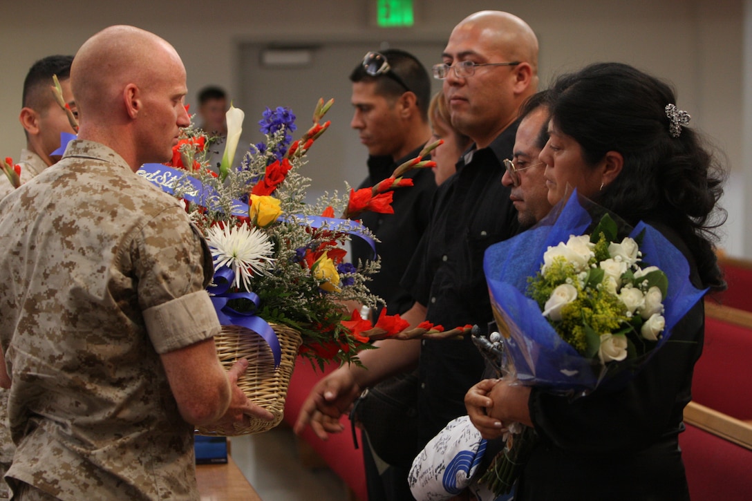 Marines pay their respects to the families of Lance Cpl. Julio Galvan, a 21-year-old automotive diesel mechanic with 3rd Combat Engineer Battalion and Maywood, Ill., native, and Pfc. Isidro Godinez, a 19-year-old automotive diesel mechanic with 3rd CEB and a Calexico, Calif., native, during the battalion’s memorial service for the Marines at the Combat Center’s Catholic Chapel July 10.
