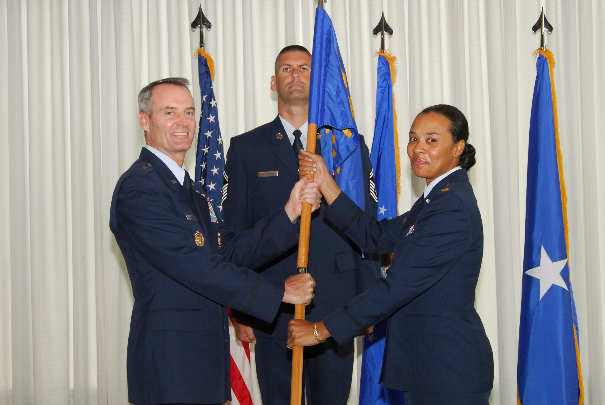(Left) Brig. Gen. Darryl Roberson, 325th Fighter Wing commander, presents the guidon to Maj. Ericka Farmer, as she takes command of the 325th Comptroller Squadron. The change of command ceremony took place July 10 at the Heritage Club. (U.S. Air Force photo/Susan Trahan)