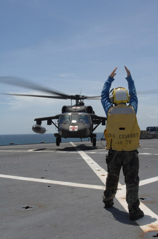 CORINTO, Nicaragua — Aviation Boatswain's Mate 3rd Class Matthew Shaw directs a UH-60 Army Blackhawk helicopter performing Deck Landing Qualifications aboard hospital ship USNS Comfort here July 9 during Continuing Promise 2009 (CP09).  The helicopter is assigned to Joint Task Force Bravo, U.S. Southern Command's forward-deployed response force stationed in Soto Cano AFB, Honduras, and is assisting CP09 teams with personnel movement and logistics here.  CP09 combines U.S. military and interagency personnel, non-governmental organizations, civil service mariners, academic and partner nations to provide medical, dental, veterinary and engineering services afloat and ashore alongside host nation personnel.  (U.S. Air Force photo by Senior Airman Jessica Snow)