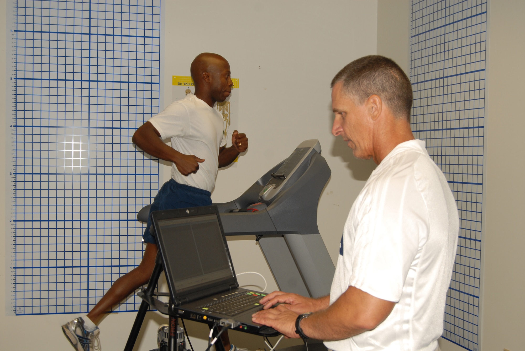 Tech. Sgt. Terrence Bessellieu, a Pope Fitness Center instructor, takes a turn on the treadmill as the HAWC’s Fitness Program Manager, Kevin Davalos, performs a gait analysis of his session.(U.S. Photo by Rhonda Griffin)