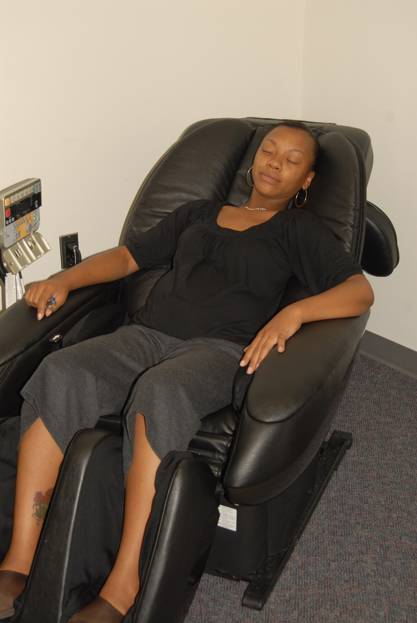 LaTreva Rush, the health educator at the Health and Wellness Center, takes a minute out of her busy day to demonstrate the relaxation chair, one of the many perks of visiting the HAWC. (U.S. Photo by Rhonda Griffin)