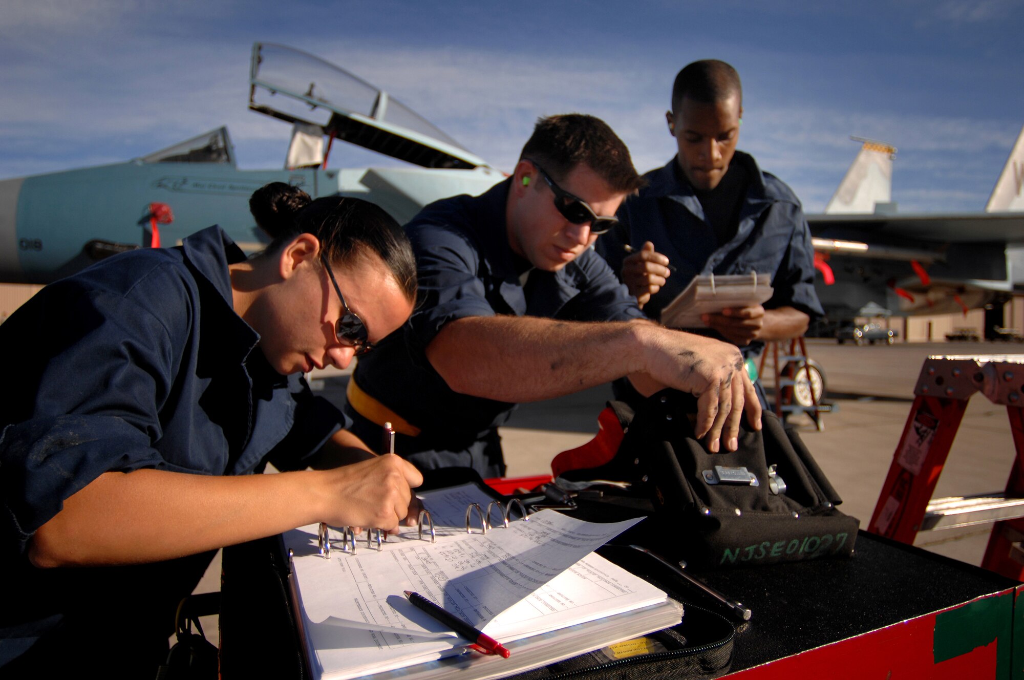 (left to right) Airman 1st Class Kayce Stout Senior Airman Jesse McCullough and Staff Sgt. Antonio Cook from the 57th Aircraft Maintenance Squadron, Eagle AMU complete final checklist items during a weapons load competition at Nellis Air Force Base, Nev., on July 8, 2009. Weapons load competitions are conducted bi-monthly to keep Airman sharp while recognizing a job well done.  Weapons Load Crews are evaluated for use of the checklist, safety, and overall speed. (U.S. Air Force Photo/Tech. Sgt. Michael R. Holzworth)

