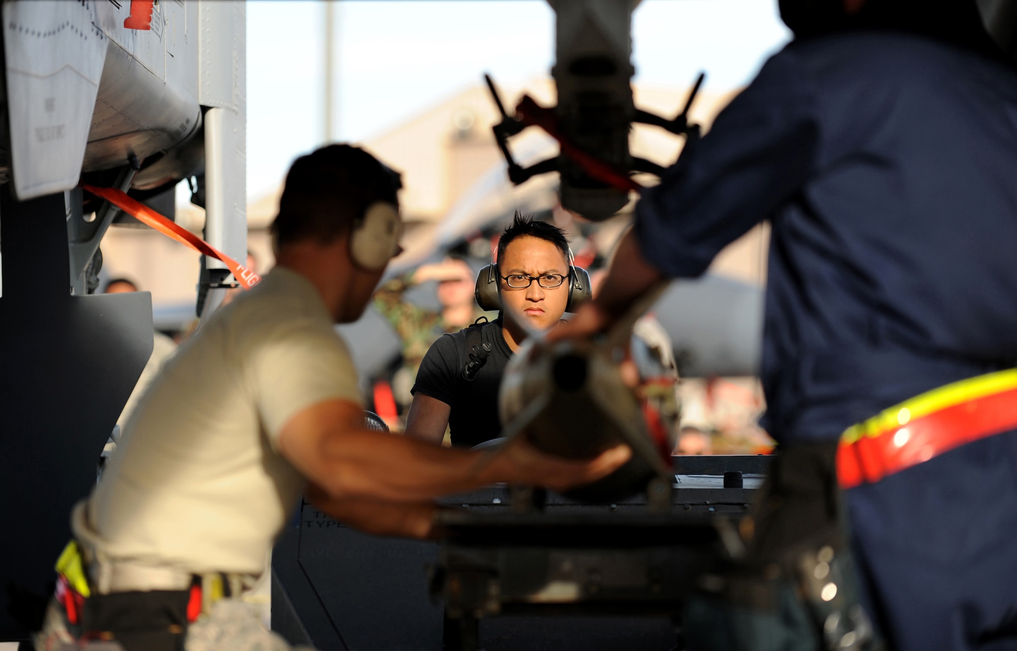 Senior Airman Wilfredo Rivera, Senior Airman Nicholas Lee, and Senior Airman Nicholaus Rossi from the 57th Aircraft Maintenance Squadron, Thunder AMU use a MJ-1 (Jammer) to position an MK-182 bomb on a A-10 Thunderbolt during a weapons load competition at Nellis Air Force Base, Nev., on July 8, 2009. Weapons load competitions are conducted bi-monthly to keep Airman sharp while recognizing a job well done.  Load Crews are evaluated for use of the checklist, safety, and overall speed.(U.S. Air Force Photo/Tech. Sgt. Michael R. Holzworth)
