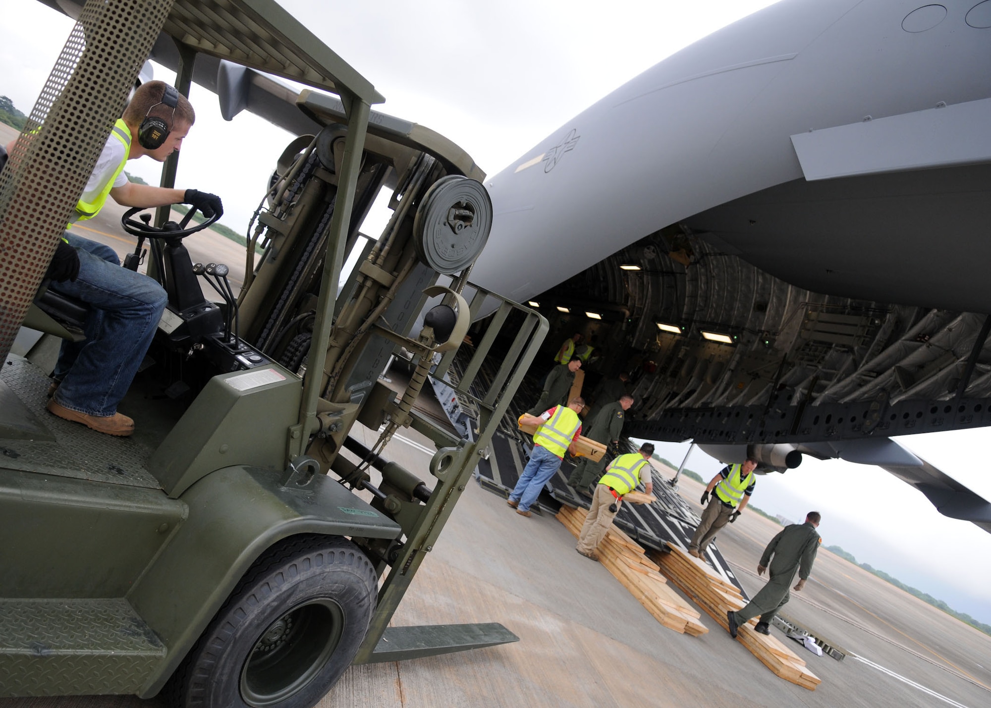 Members of the 621st Contingency Response Wing, McGuire Air Force Base, N.J., along with C-17 aircrew members from Charleston Air Force Base, South Carolina, work together during offloading operations of a stair truck at Kotoka International Airport July 6, 2009, at Accra, Ghana. T

he Airmen are among more than 150 Airmen, Sailors and Marines in Ghana and Sailors aboard the USS Iwo Jima who form a task force supporting U.S. President Barack Obama’s visit July 10 and 11. The mission is being conducted by 17th Air Force, also known as Air Forces Africa, at Ramstein Air Base, Germany. Seventeenth Air Force is the air component for U.S. Africa Command. The task force is providing aerial port and aircraft maintenance teams, along with forward communications, early warning and air domain safety and security elements to support the President’s visit, his first to the African continent since taking office in January. In addition to supporting the visit, members are working with their Ghanaian counterparts to strengthen the partnership between the two nations. (U.S. Air Force photo by Staff Sgt. Jerry Fleshman)