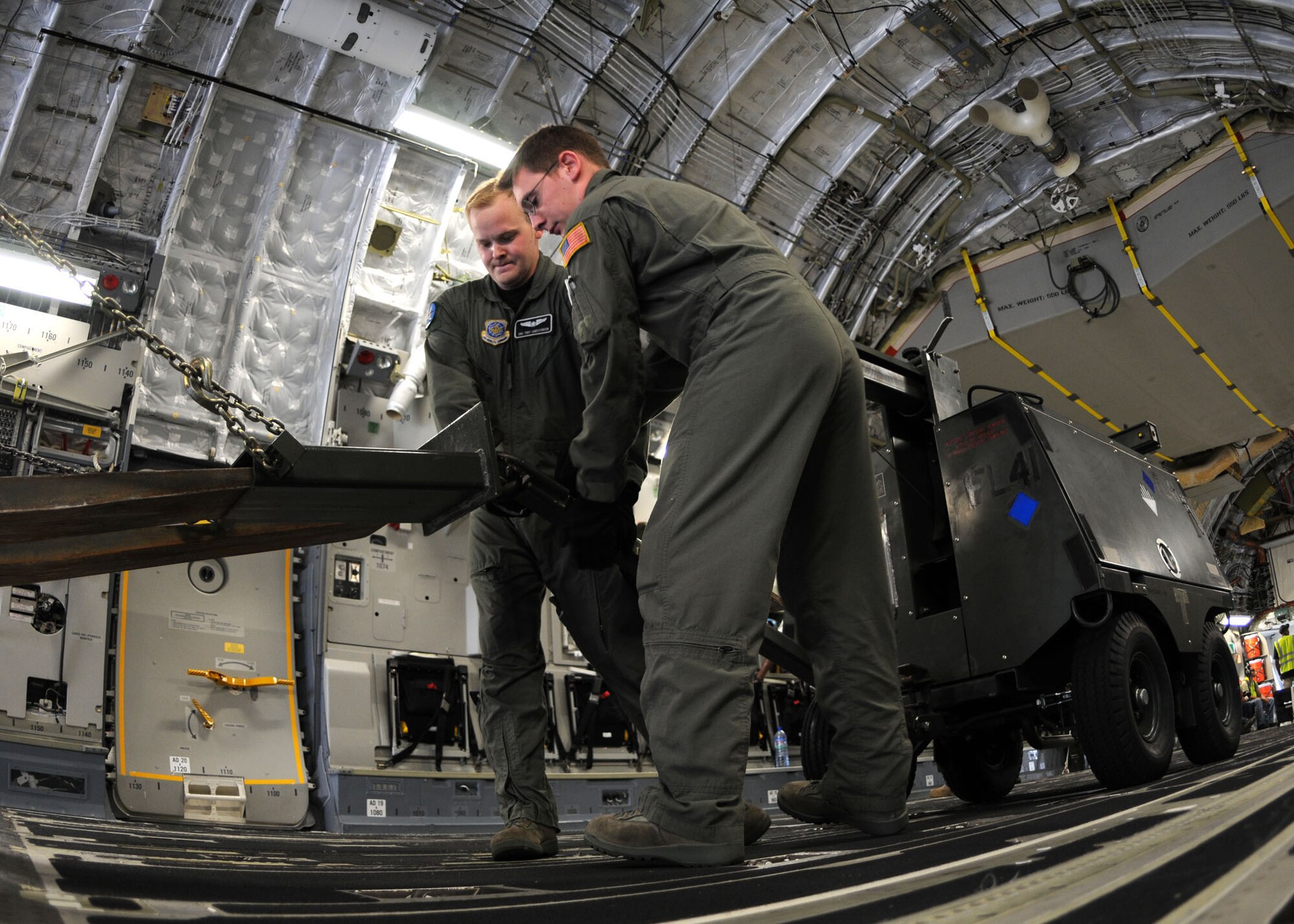 Senior Airmen Toby Christiensen and Paul Hedges, load masters with the 8th Airlift Squadron, McChord Air Force Base, Wash., connect a floodlight to a forklift during offloading operations of aerospace ground equipment at Kotoka International Airport July 6, 2009, at Accra, Ghana. 

The Airmen are among more than 150 Airmen, Sailors and Marines in Ghana and Sailors aboard the USS Iwo Jima who form a task force supporting U.S. President Barack Obama’s visit July 10 and 11. The mission is being conducted by 17th Air Force, also known as Air Forces Africa, at Ramstein Air Base, Germany. Seventeenth Air Force is the air component for U.S. Africa Command. The task force is providing aerial port and aircraft maintenance teams, along with forward communications, early warning and air domain safety and security elements to support the President’s visit, his first to the African continent since taking office in January. In addition to supporting the visit, members are working with their Ghanaian counterparts to strengthen the partnership between the two nations. (U.S. Air Force photo by Staff Sgt. Jerry Fleshman)