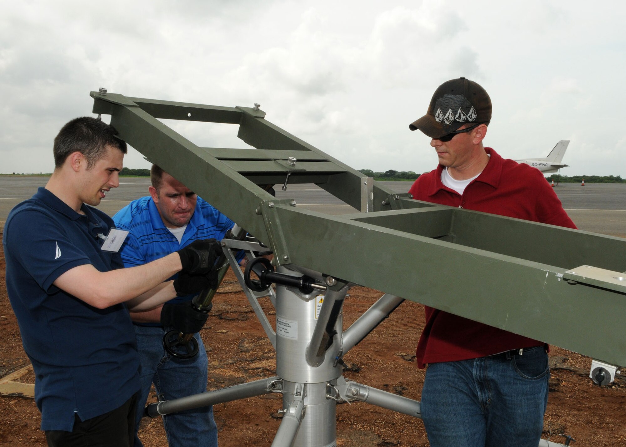 (Left to right) Senior Airman Kirk Rodgers, Staff Sgt. Jay Pernie, and Staff Sgt. Steven Humphrey set up satellite communications at Kotoka International Airport July 1, 2009, at Accra, Ghana. 

The Airmen are members of the 1st Combat Communications Squadron at Ramstein Air Base, Germany, and are among more than 150 Airmen, Sailors and Marines in Ghana and Sailors aboard the USS Iwo Jima who form a task force supporting U.S. President Barack Obama’s visit July 10 and 11. The mission is being conducted by 17th Air Force, also known as Air Forces Africa, at Ramstein Air Base, Germany. Seventeenth Air Force is the air component for U.S. Africa Command. The task force is providing aerial port and aircraft maintenance teams, along with forward communications, early warning and air domain safety and security elements to support the President’s visit, his first to the African continent since taking office in January. In addition to supporting the visit, members are working with their Ghanaian counterparts to strengthen the partnership between the two nations. (U.S. Air Force photo by Master Sgt. Jim Fisher)