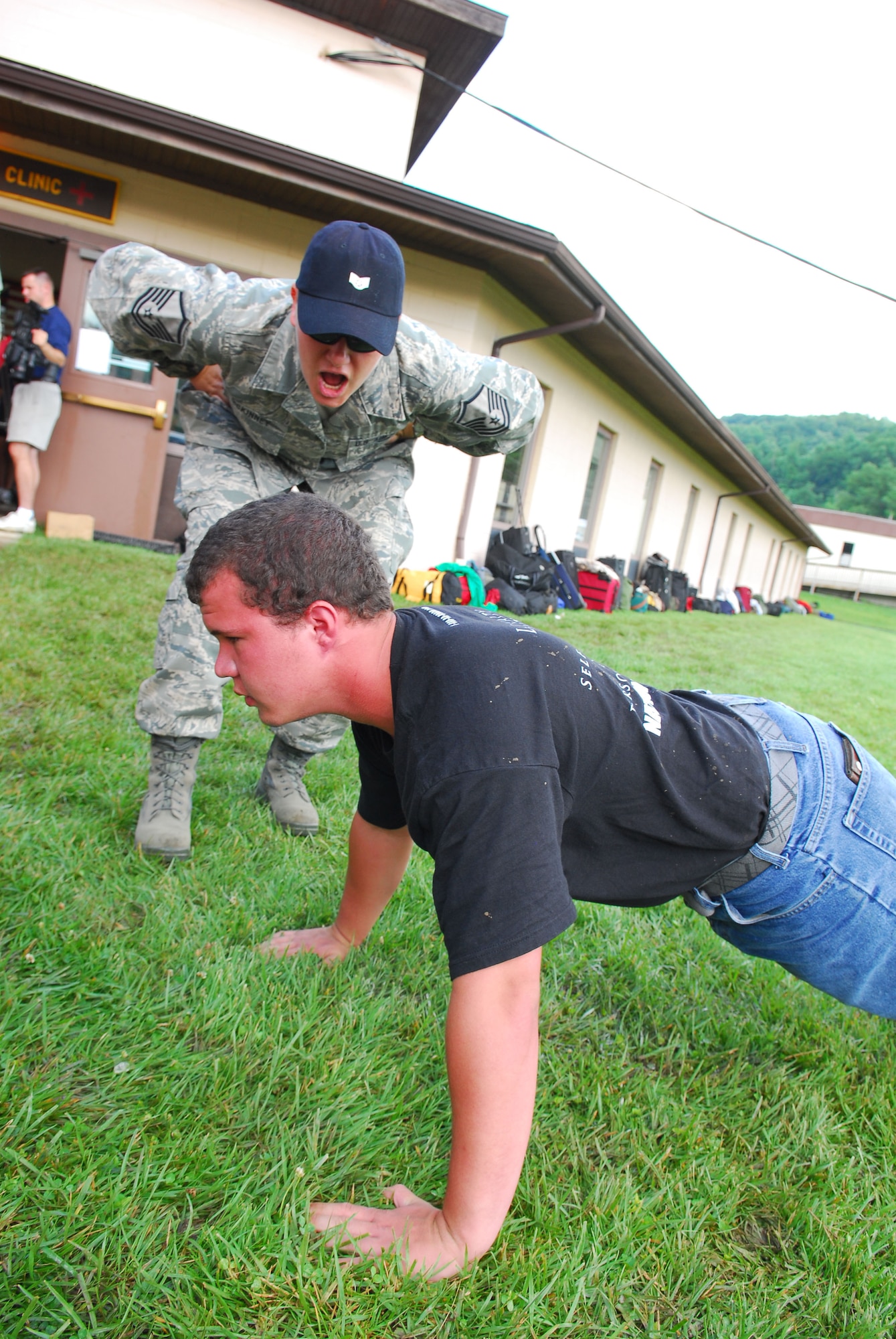 167th Airlift Wing member, Master Sergeant Kelley McKinney, a TAC (Train, Advise, Counsel) leader for the West Virginia Youth Leaders Camp, instructs a camper on proper push-up technique on the first day of the camp at Camp Dawson near Kingwood, WV. Sixty-six high schoolers from West Virginia participated in the week-long camp now in its forty-third year. Youth Leaders Camp, geared toward building confidence and instilling leadership skills, challenges the campers with mentally and physically demanding activities. (U.S. Air Force Photo by MSgt Emily Beightol-Deyerle)