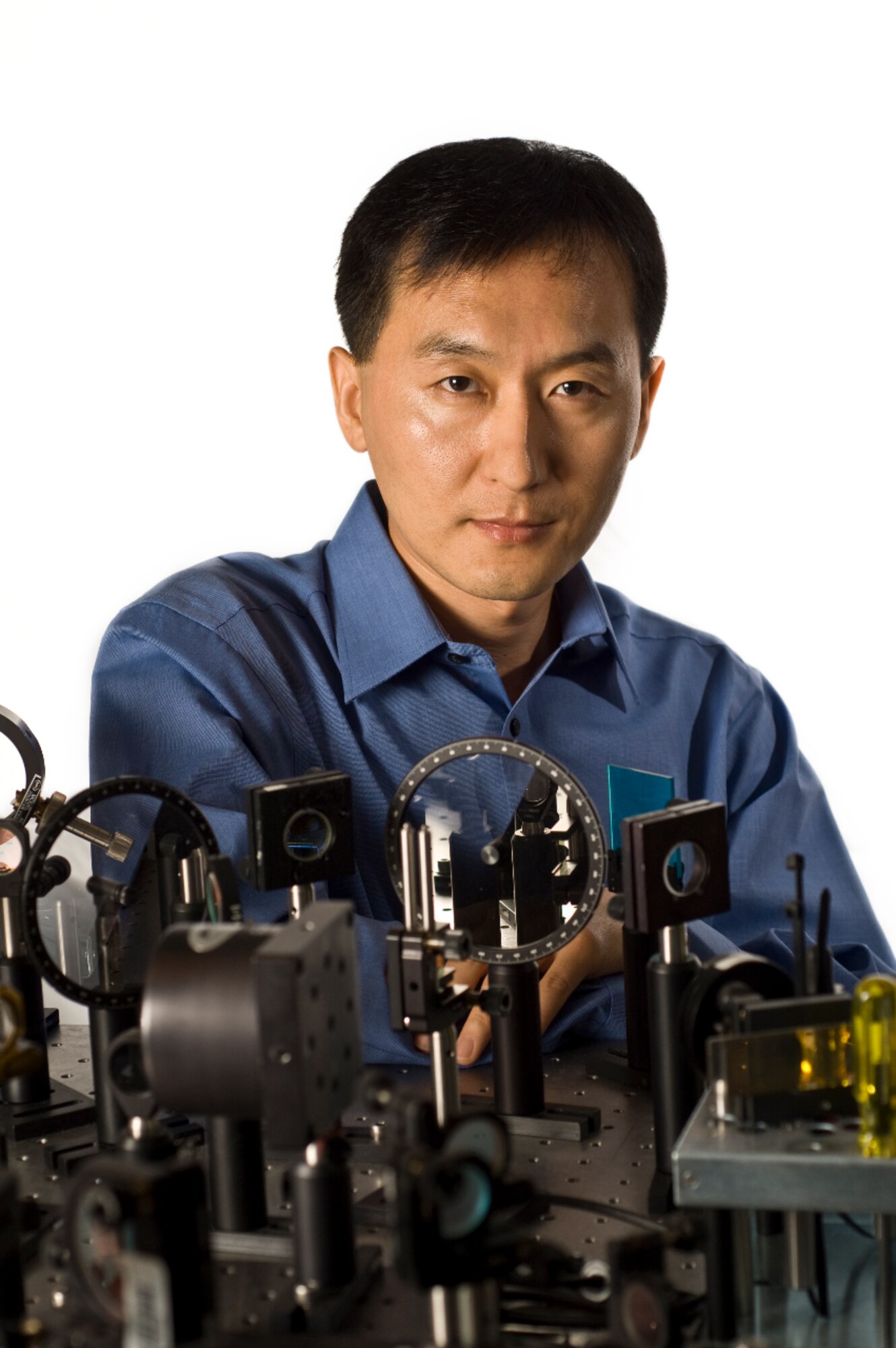 Dr. Chunlei Guo of the University of Rochester stands in front of his femtosecond laser. (Credit: Walter Colley Studio)