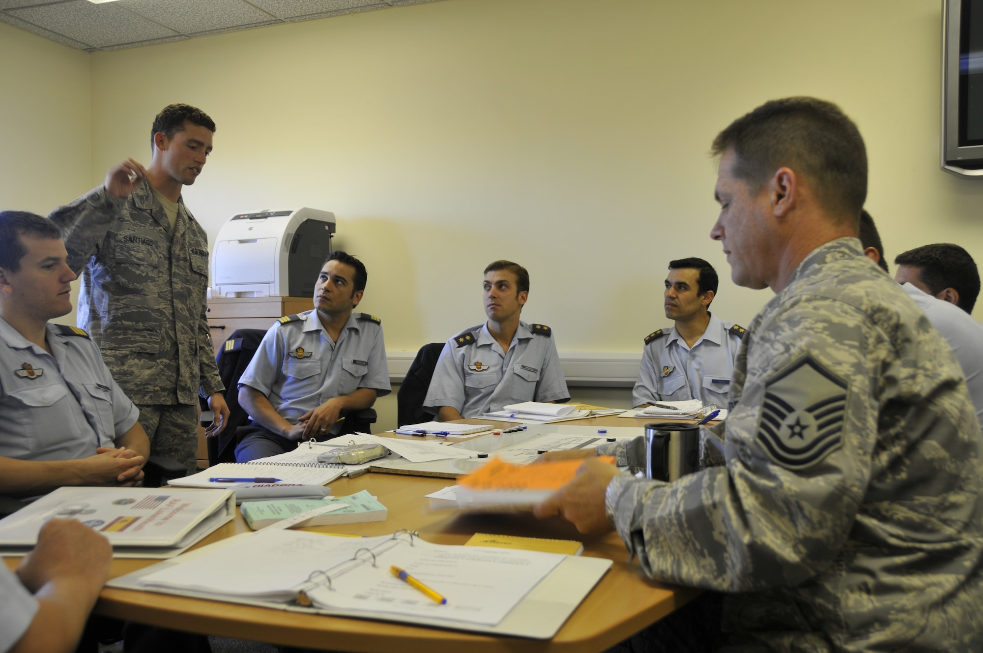 Senior Airman Carlos Santiago (standing left), 48th Operations Support Squadron air traffic controller, instructs Spanish air traffic controllers on the ground control procedures for a NATO location while Master Sgt. James Armstrong (right), 48th OSS Air Traffic Control watch supervisor, instructs the same students on the local control position (talking to planes in the air) procedures for the same location. The Spanish controllers were at RAF Lakenheath to become familiar with American phraseology (specific verbiage used to talk to aircraft) and procedures prior to their deployment. (U.S. Air Force photo by Tech. Sgt. Chris Stagner)