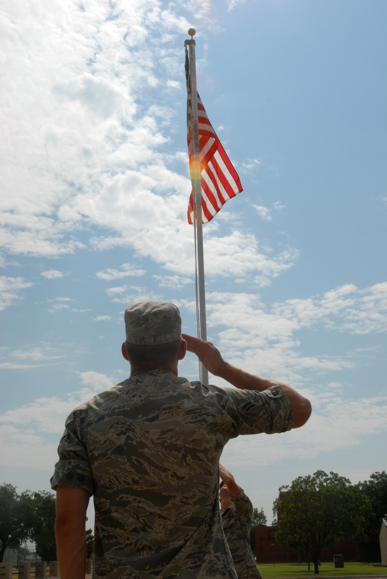 A student from the 315th Training Squadron salutes a flag as it is lowered. (U.S. Air Force photo by Airman Clayton Lenhardt)