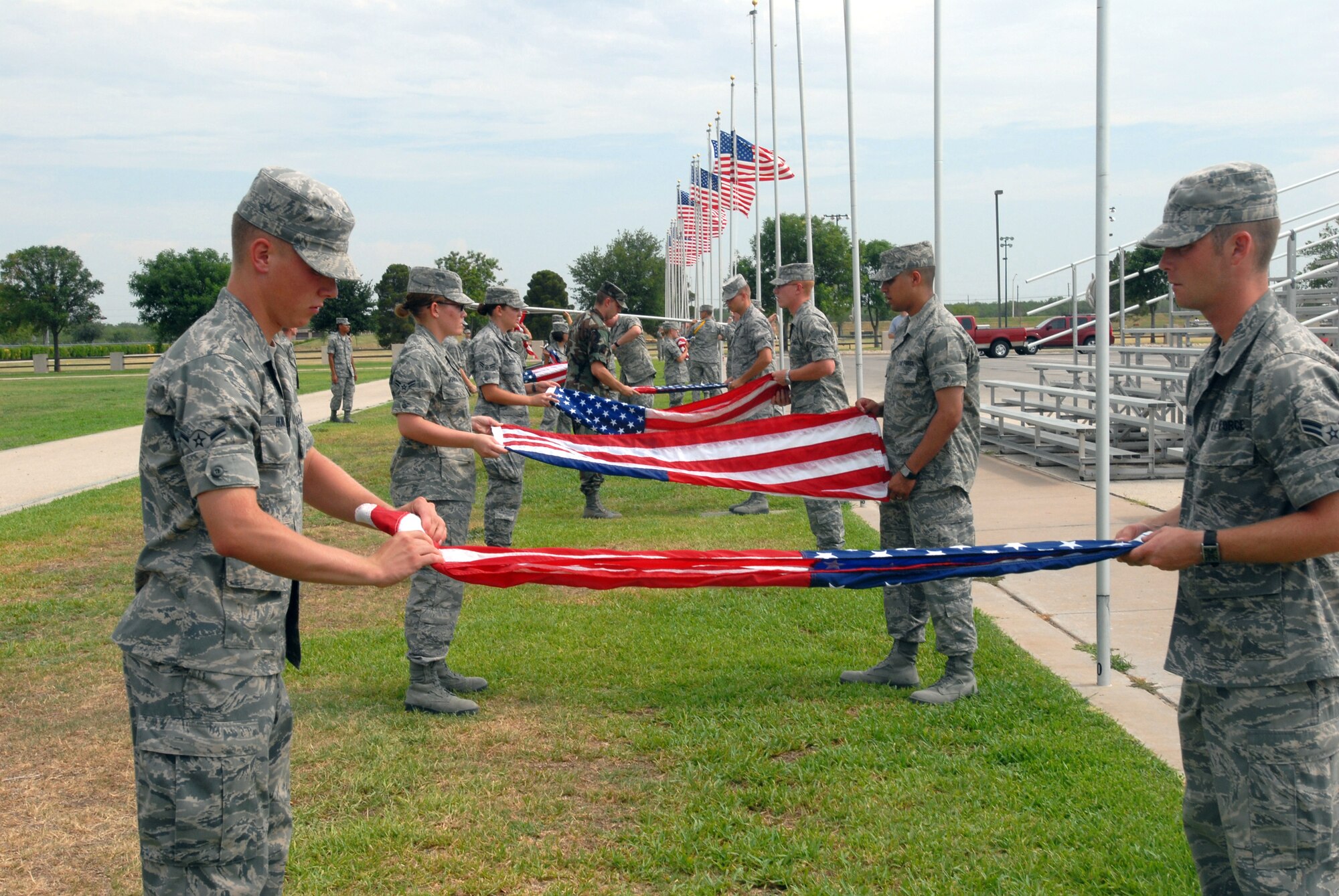 Students from the 315th Training Squadron lower and fold flags before retreat. (U.S. Air Force photo by Airman Clayton Lenhardt)