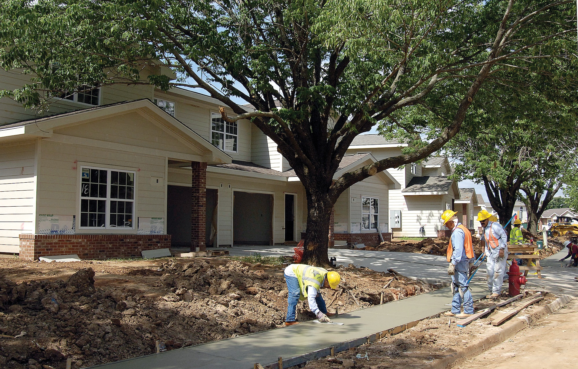 Construction crews pour sidewalks July 6 along Twining. Houses in every stage of construction line the street. (Air Force photo by Margo Wright)