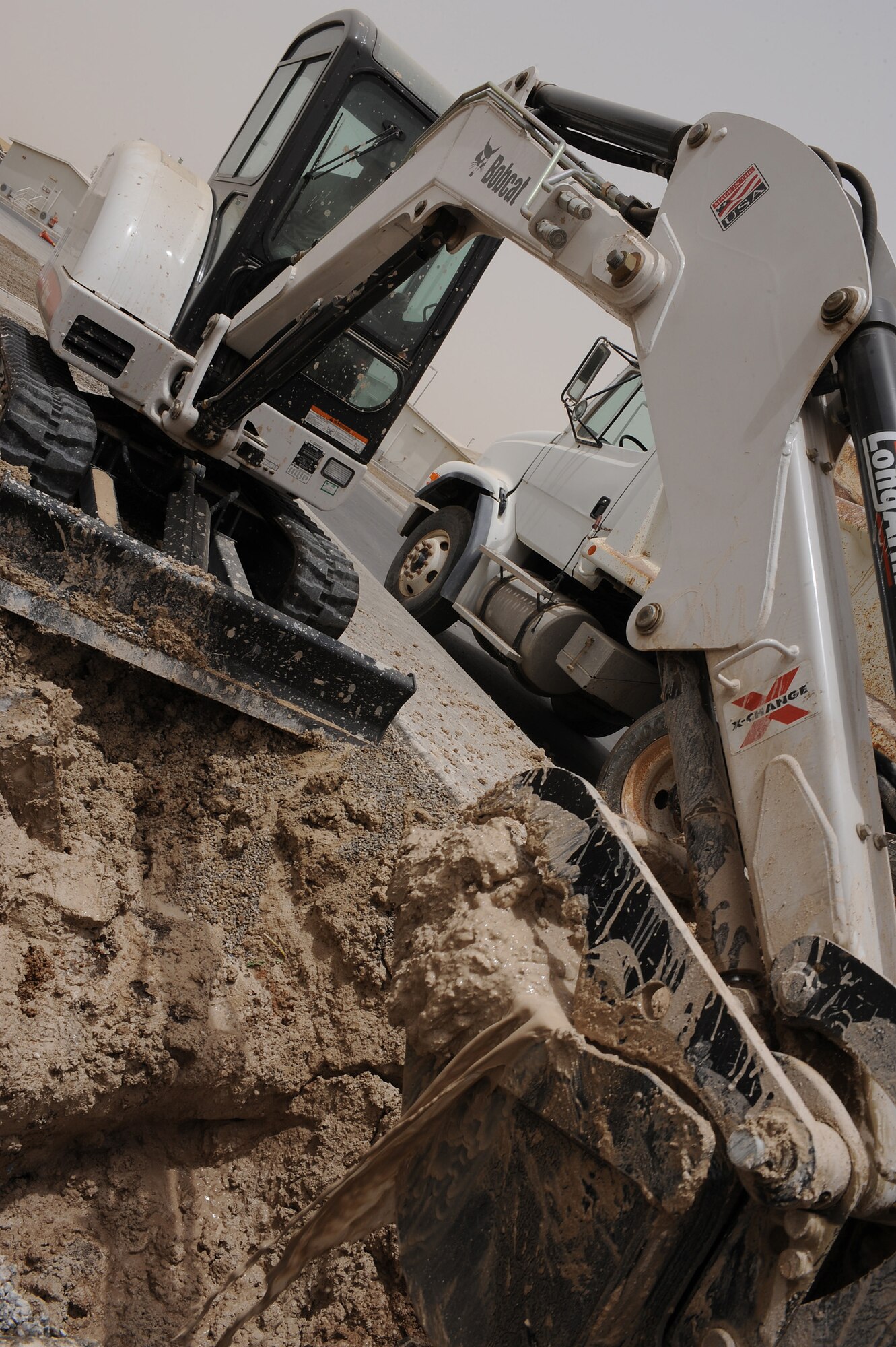 SOUTHWEST ASIA - Staff Sgt. Nicholas Haasch, a 380th Expeditionary Civil Engineer Squadron heavy equipment operator, uses an excavator to remove dirt from around a broken water pipe, July 6 in Southwest Asia. The pipe sprung a leak when the mechanical flange that connects the valve to the pipe lost its seal. (U.S. Air Force photo by Senior Airman Brian J. Ellis)