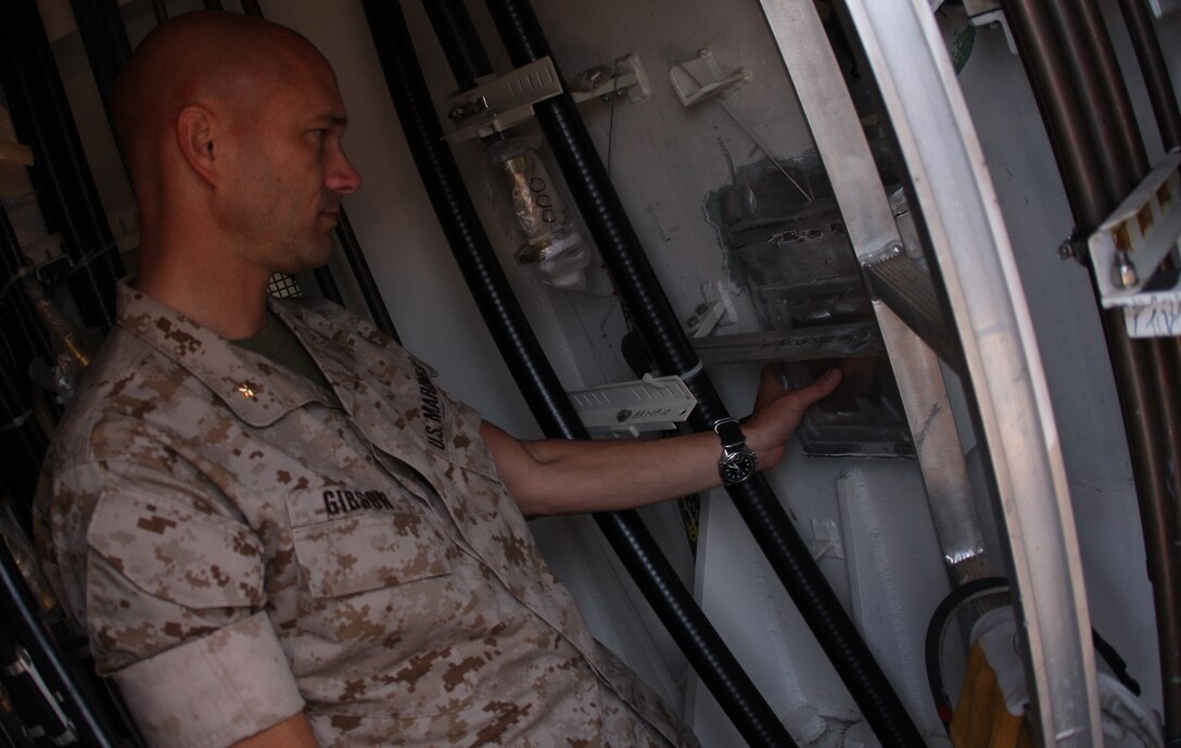 Maj. Trent A. Gibson, the executive officer of 2nd Battalion, 7th Marine Regiment, and Medal of Honor recipient Cpl. Jason Dunham’s former company commander, takes a moment to reflect after wielding the final tack on a box containing items representing Dunham's legacy in the mast of the Navy destroyer bearing Dunham’s name after he put the final weld into place July 11 during the ship’s mast stepping ceremony.