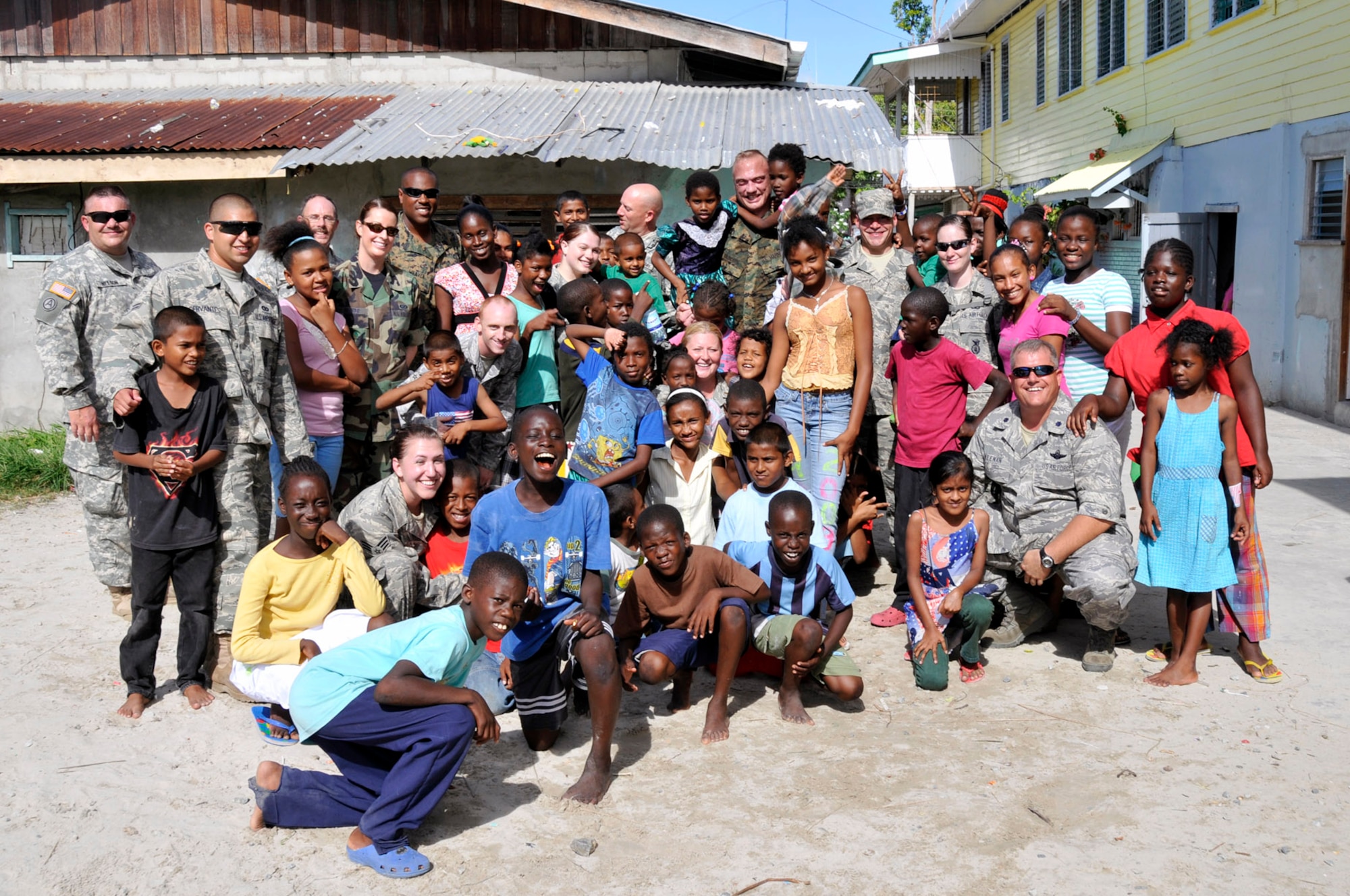 Members of Joint Task Force Guyana pose for a group photo with the children of Joshua's Place orphanage, July 5, 2009 in Georgetown, Guyana. Airmen, Marines, and Soldiers visited the orphanage to get information on what kind of support JTF Guyana can provide. (U.S. Air Force photo by Airman 1st Class Perry Aston)