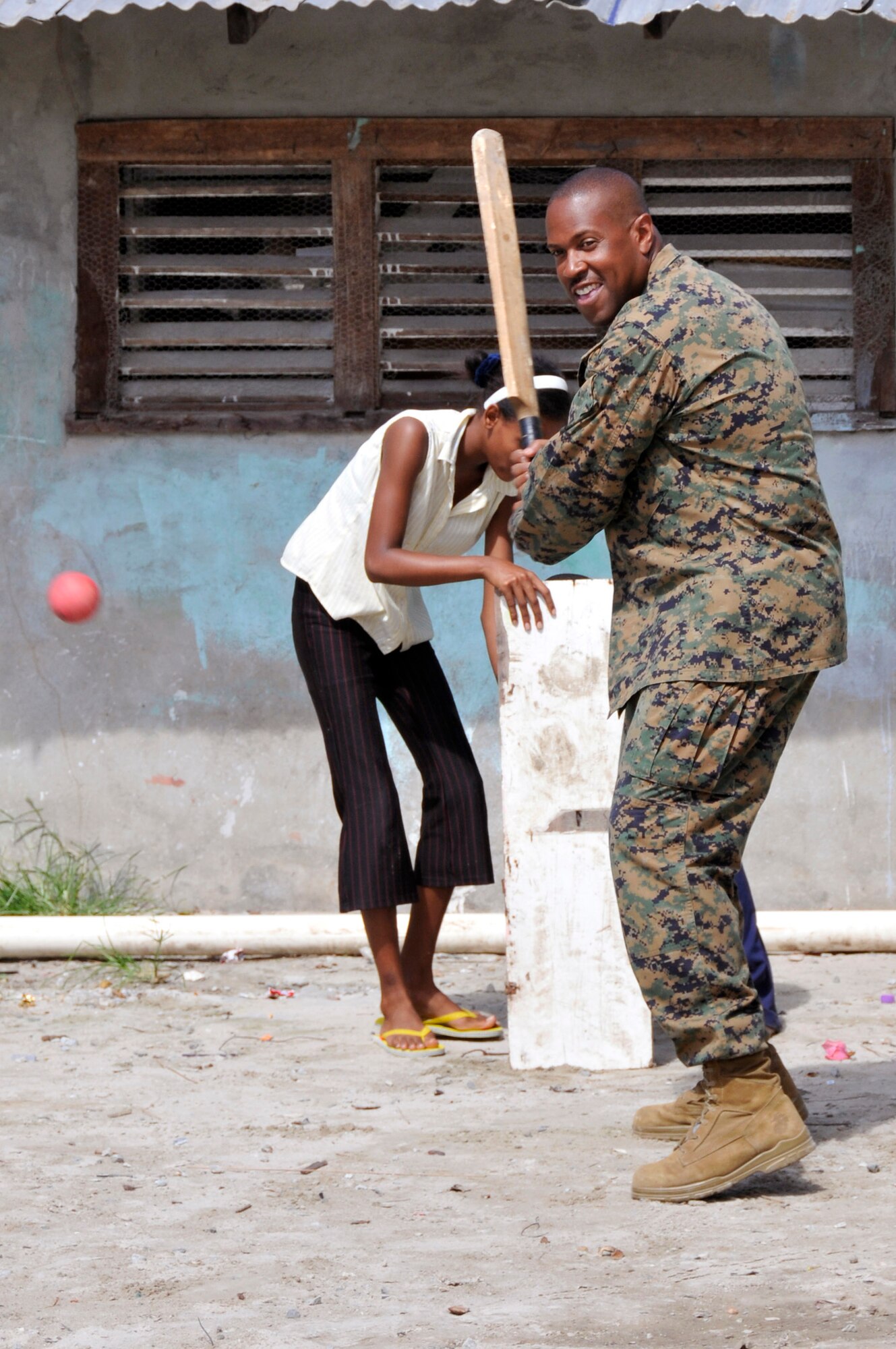 Master Gunnery Sgt. Artis Weaver, Joint Task Force Guyana chief enlisted officer, plays a game of cricket with the children at Joshua's Place orphanage July 5, 2009 in Georgetown, Guyana. Airmen, Marines, and Soldiers visited the orphanage to find out what they could do to help the orphanage. Master Gunnery Sgt. Weaver is deployed from Marine Aviation Logistics Squadron 49, Naval Air Station Willow Grove, and hails from Fort Washington, Maryland. (U.S. Air Force photo by Airman 1st Class Perry Aston)