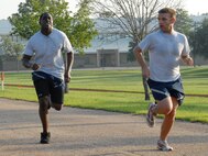 Staff Sgt. Cecil Guy motivates Airman 1st Class Johnathan Whitehurst, 919th Services Flight, along as he heads for the finish of the 1.5 mile run July 12 during the UTA weekend at Duke Field.  Services and 919th Logistics Readiness Squadron began early at 7 a.m. for the testing.  New Air Force guidance on PT testing was released in June to take effect in 2010.  Some of the new changes include bi-annual testing and more points awarded to the run time.  (U.S. Air Force photo/Staff Sgt. Samuel King Jr.)