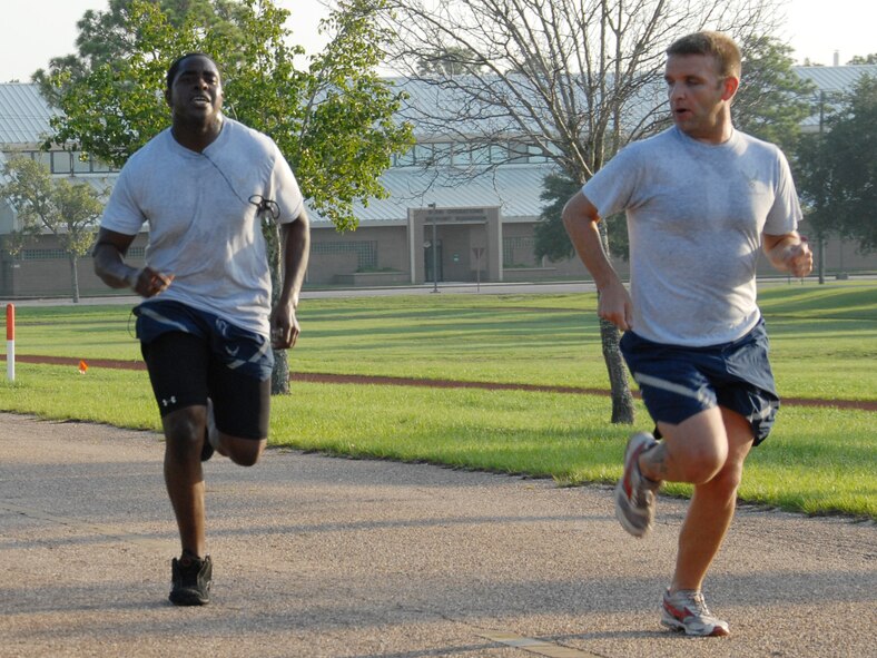 Staff Sgt. Cecil Guy motivates Airman 1st Class Johnathan Whitehurst, 919th Services Flight, along as he heads for the finish of the 1.5 mile run July 12 during the UTA weekend at Duke Field.  Services and 919th Logistics Readiness Squadron began early at 7 a.m. for the testing.  New Air Force guidance on PT testing was released in June to take effect in 2010.  Some of the new changes include bi-annual testing and more points awarded to the run time.  (U.S. Air Force photo/Staff Sgt. Samuel King Jr.)