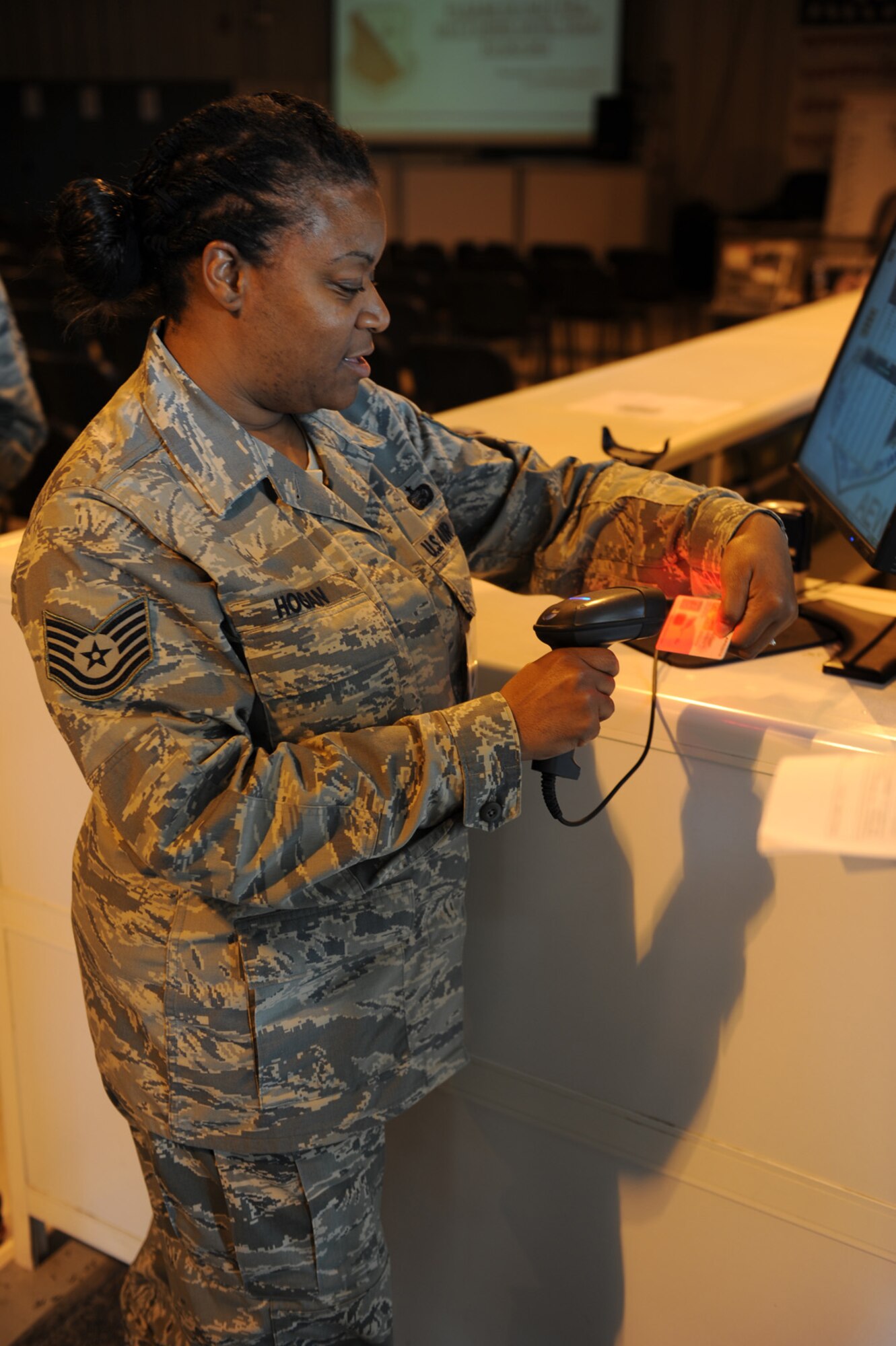 Tech. Sgt. Devon Hogan, 379th Expeditionary Mission Support Group, scans the identification cards of in-processing Airmen as they go through Personnel Support for Contingency Operations as part of their deployment here in Southwest Asia. Sergeant Hogan hails from Bronx, N.Y. and is deployed from Aviano Air Base, Italy, in support of Operations Iraqi Freedom, Enduring Freedom and the Combined Joint Task Force-Horn of Africa. (U.S. Air Force photo/Staff Sgt. Robert Barney)