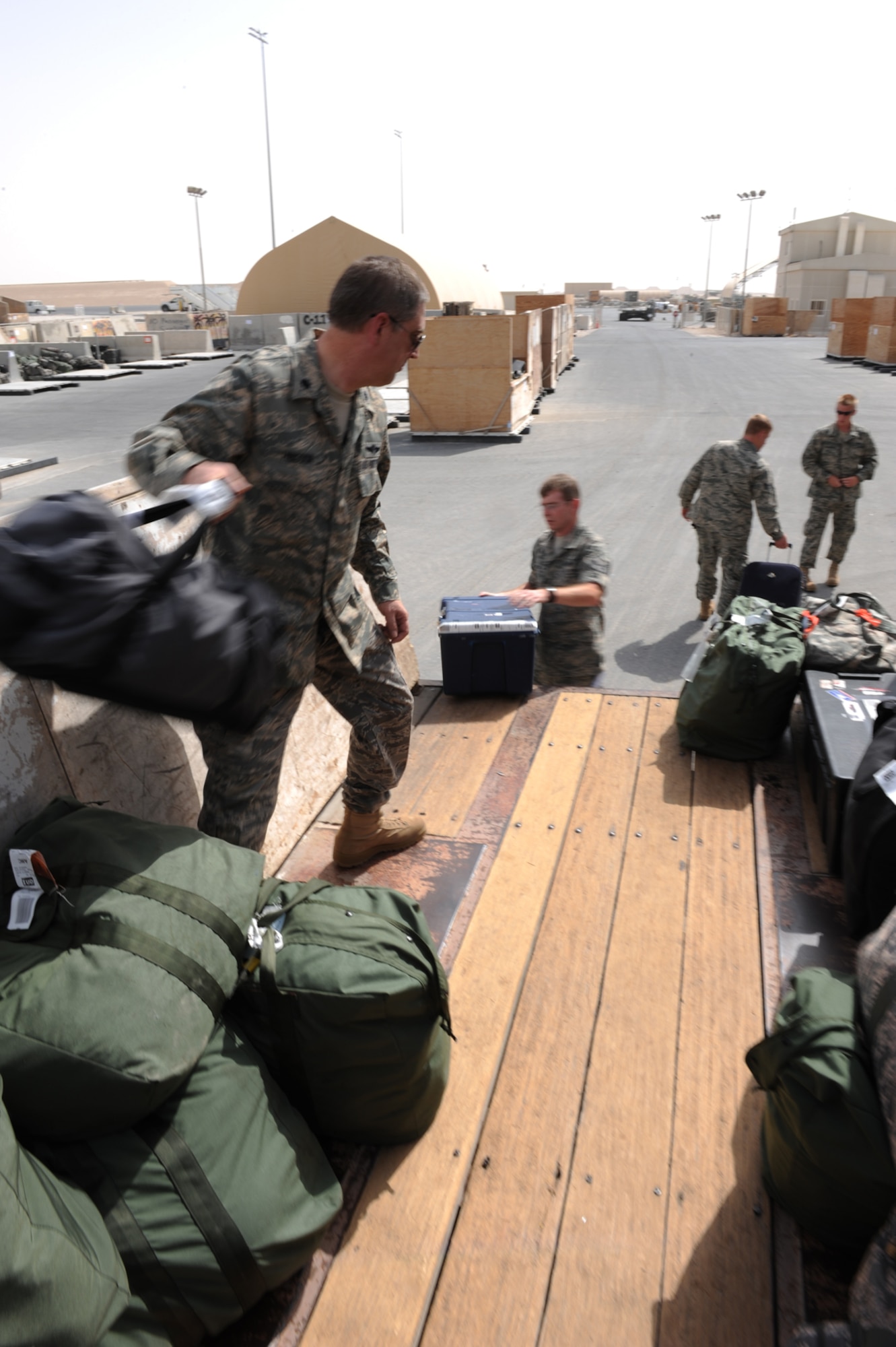 Lt. Col. Stephen Hingson helps unload baggage before processing through the Personnel Support for Contingency Operations here, July 8. Colonel Hingson was redeploying from the U.S. Central Command area of responsibility to his home station at Minot AFB, N.D. (US Air Force photo/Staff Sgt. Robert Barney)
