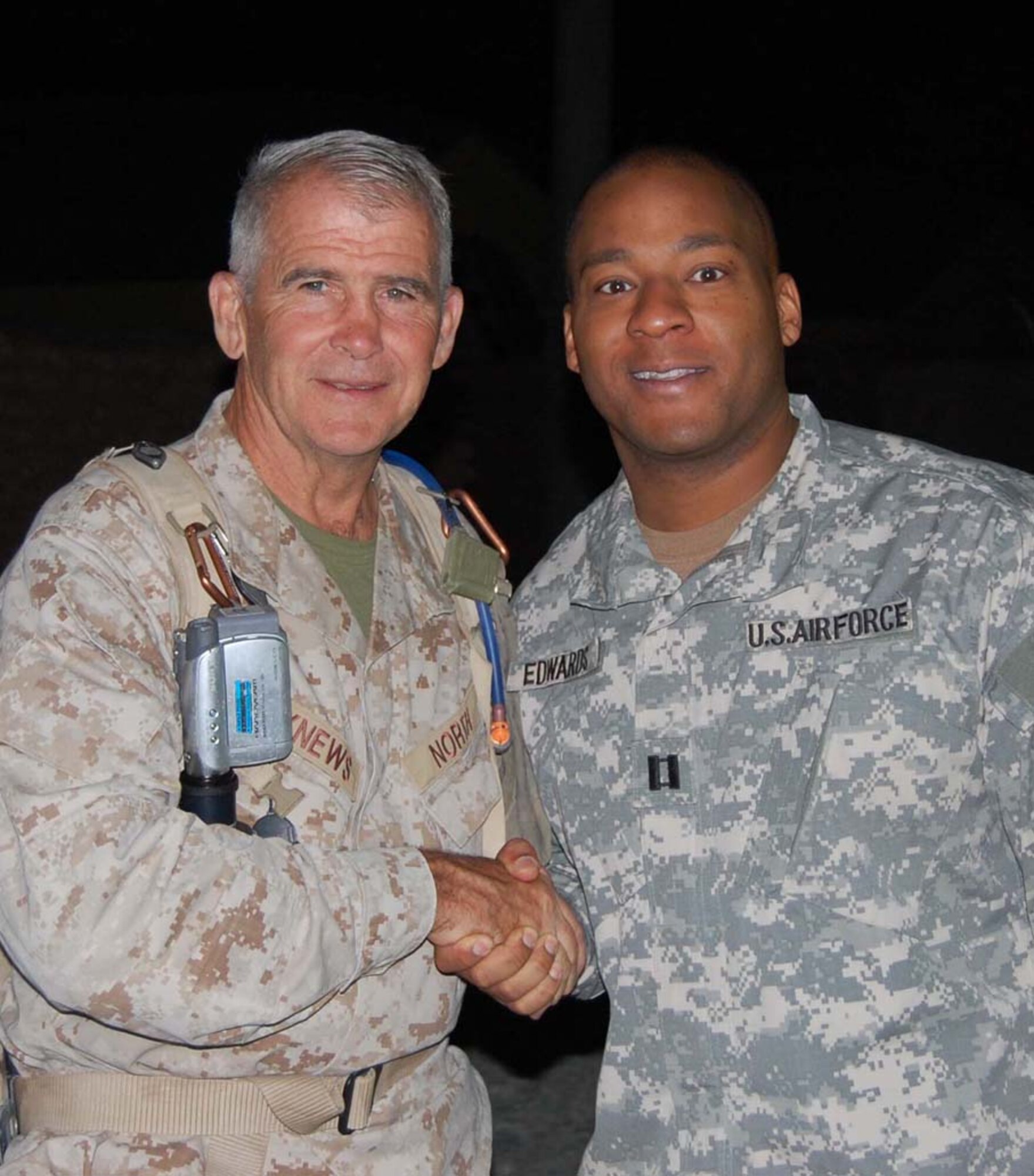 Maj. (then captain) Tony Edwards (right) meets retired Marine Lt. Col. Oliver North in Afghanistan.  Major Edwards, a Reservist assigned to the 446th Logistics Readiness Flight, McChord Air Force Base, Wash., earned the Bronze Star while deployed to Afghanistan for six months. Colonel North was in Afghanistan filming a documentary. (Courtesy photo)