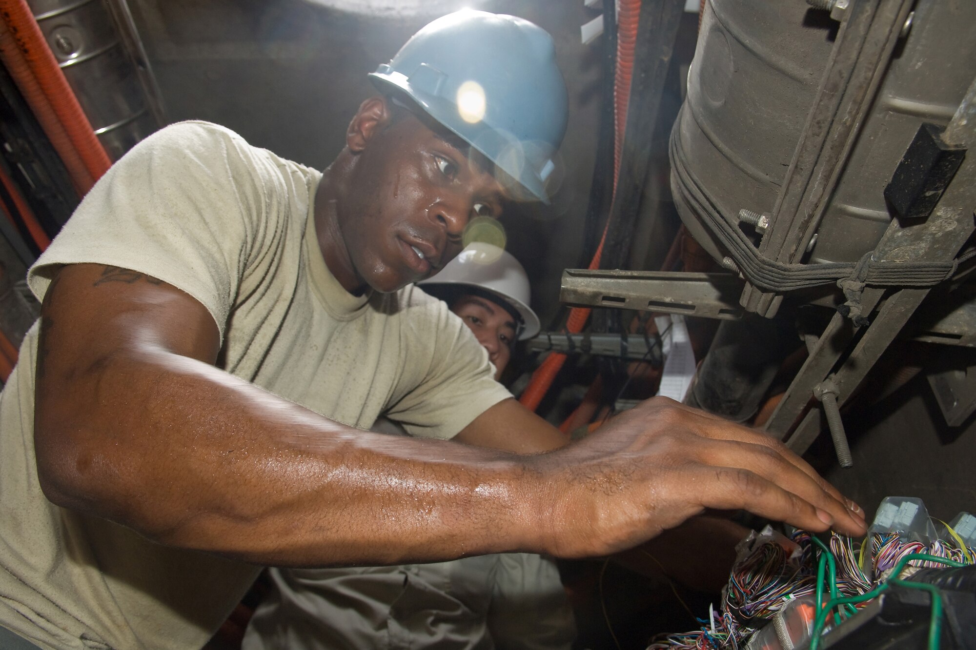 YOKOTA AIR BASE, Japan -- Senior Airman Lakendrick Fisher, 374th Communications Squadron Cable and Antenna Maintenance Shop, repairs telephone cables July 13 damaged during a fire on base earlier this year. Shop members install many telephone and fiber cables underground and maintain above- and below-ground communication lines. (U.S. Air Force photo/Osakabe Yasuo) 