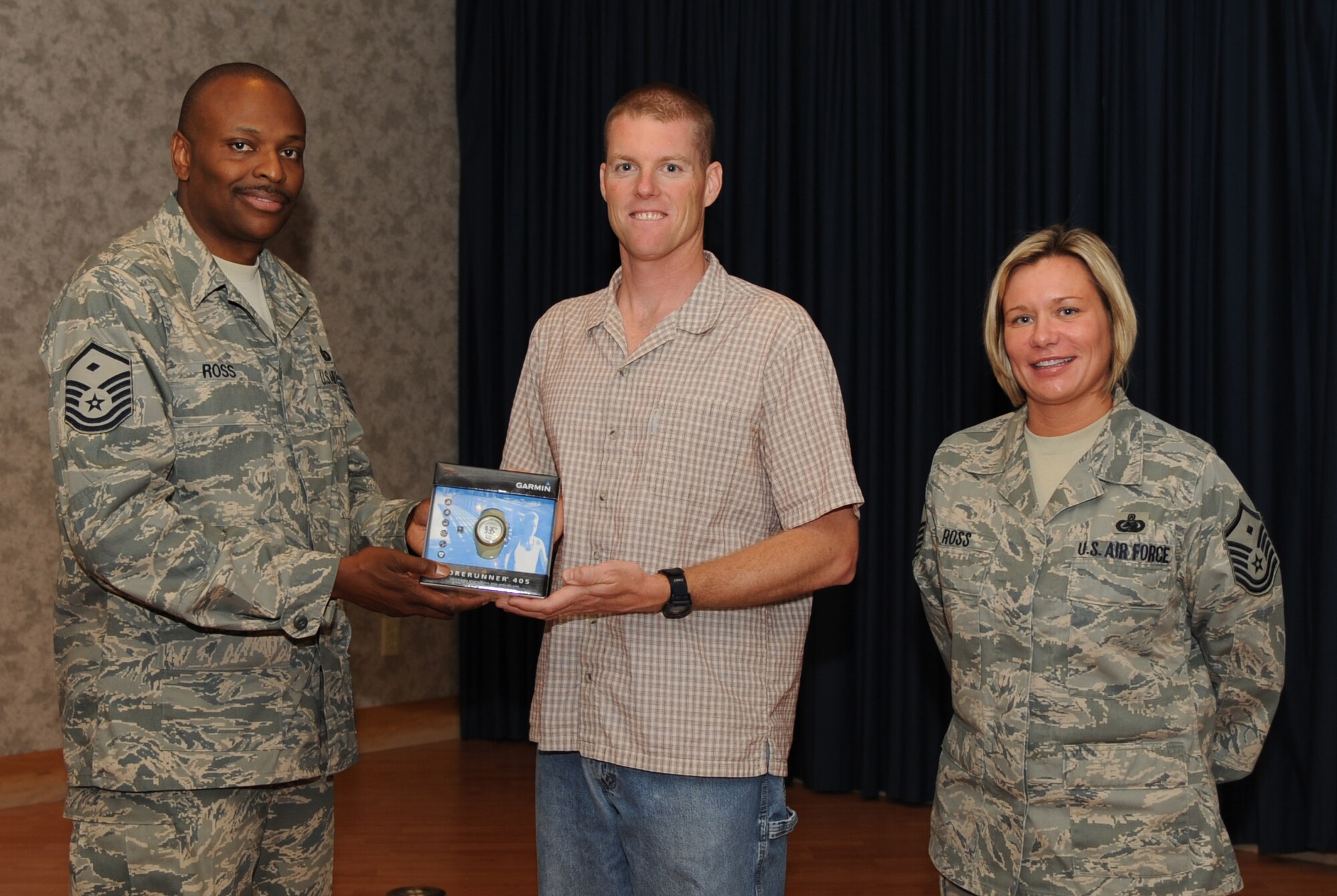 MOUNTAIN HOME AIR FORCE BASE, Idaho – Master Sgts. Darryl Ross (left), Top III Run-A-Thon coordinator and 366th Equipment Maintenance Squadron first sergeant, and Kathleen Ross, Top III president and 389th Fighter Squadron first sergeant, present Staff Sgt. Christopher Markus, 366th Logistics Readiness Squadron, with a watch for raising the most money during the run - $540. The June 26 run-a-thon was the largest Top III event in 366th Fighter Wing history with 185 Gunfighters completing 3,315 laps or 828 miles around the base track. (U.S. Air Force photo\Airman 1st Class Renishia Richards)