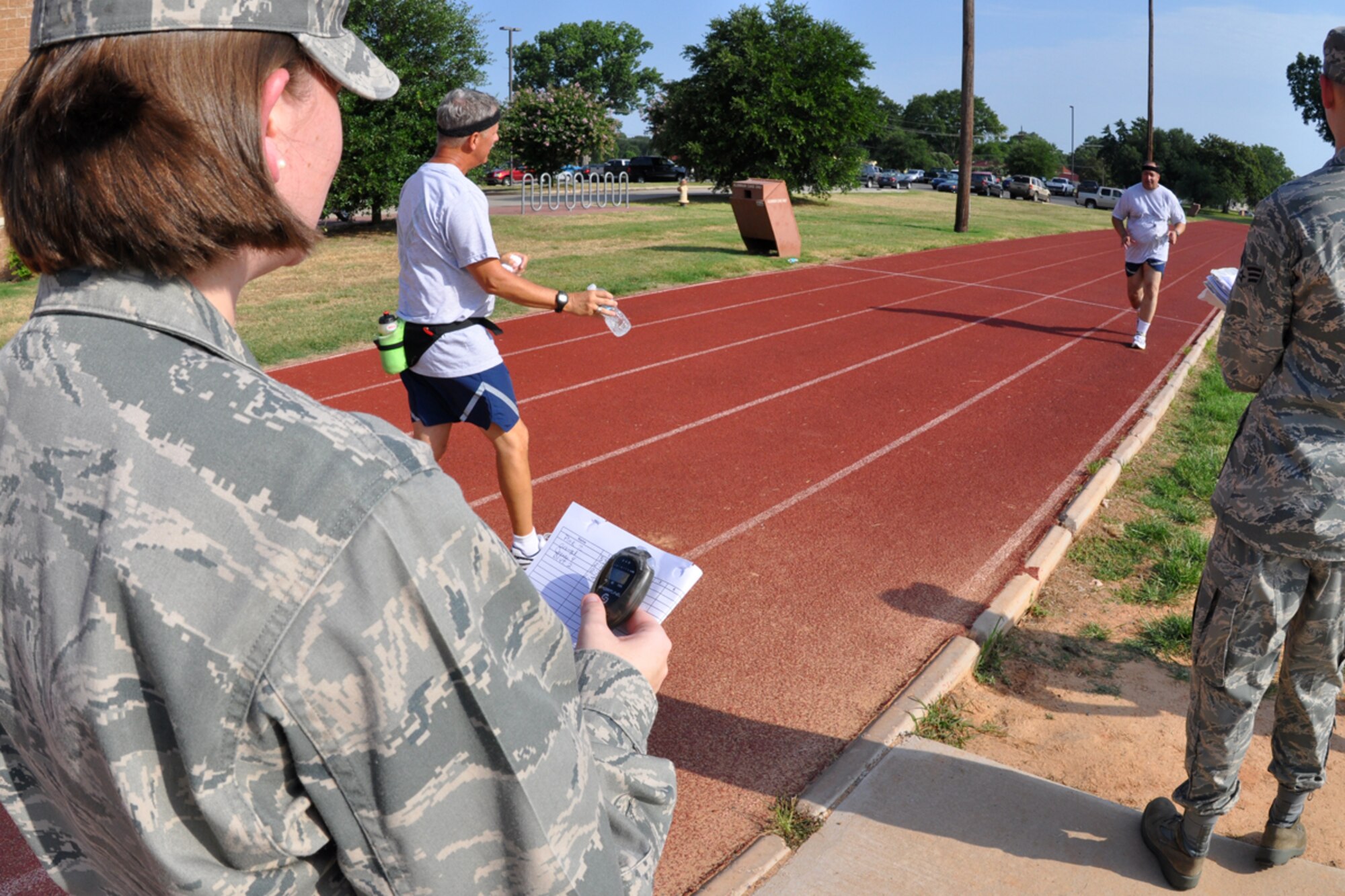 Senior Master Sgt. Dave Roberts, 917th Mission Support Flight, education and training chief, entices Lt. Col. Charles Morgan, 917th Wing, process manager, through another lap with the proverbial “carrot on a stick” during his fitness test as Capt. Stephanie Kennedy, 917th Wing, fitness coordinator, logs the colonel’s lap times at the fitness center on Barksdale Air Force Base, La., July 12, 2009. The Air Force Fitness Test is designed to test the body composition, muscular strength/endurance and cardiovascular respiratory fitness of Airmen in the U.S. Air Force. As part of the “Fit to Fight” program, the Air Force adopted a more stringent physical fitness assessment; the new fitness program was established on January 1, 2004, and replaces the annual ergo-cycle test that Air Force used before. (U.S. Air Force photo/Tech. Sgt. Jeff Walston)