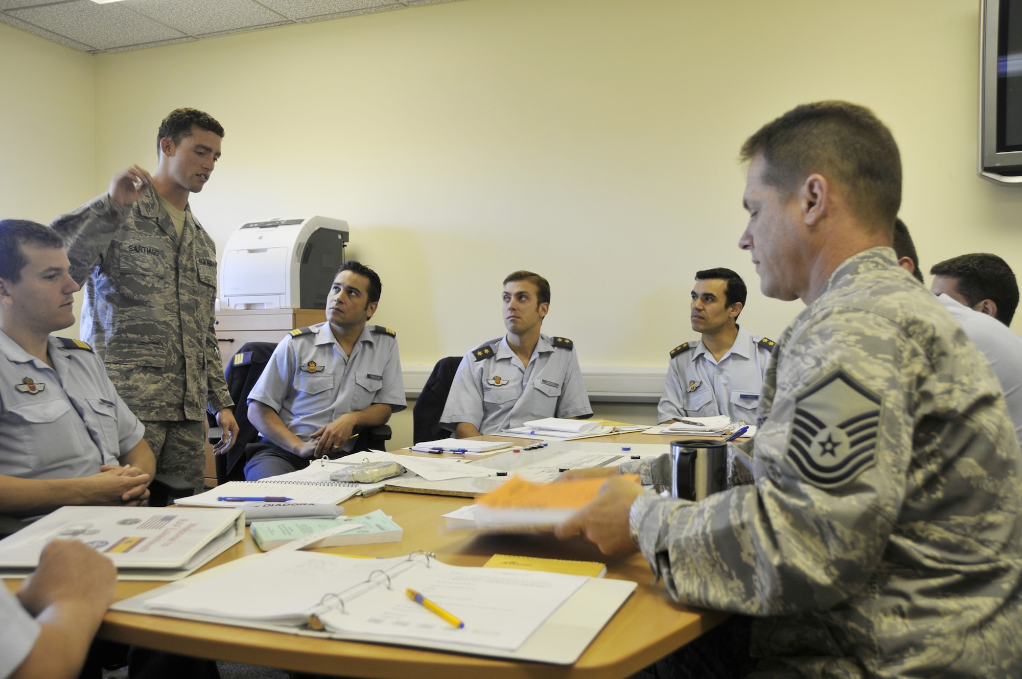 Senior Airman Carlos Santiago (standing left) instructs Spanish air traffic controllers on the ground control procedures for a NATO location while Master Sgt. James Armstrong (right) instructs the same students on the local control position procedures for the same location July 10 at Royal Air Force Lakenheath, England. The Spanish controllers were at RAF Lakenheath to become familiar with American phraseology and procedures prior to their deployment for NATO. Airman Santiago is a 48th Operations Support Squadron air traffic controller. Sergeant Armstrong is the 48th OSS air traffic control watch supervisor. (U.S. Air Force photo/Tech. Sgt. Chris Stagner) 