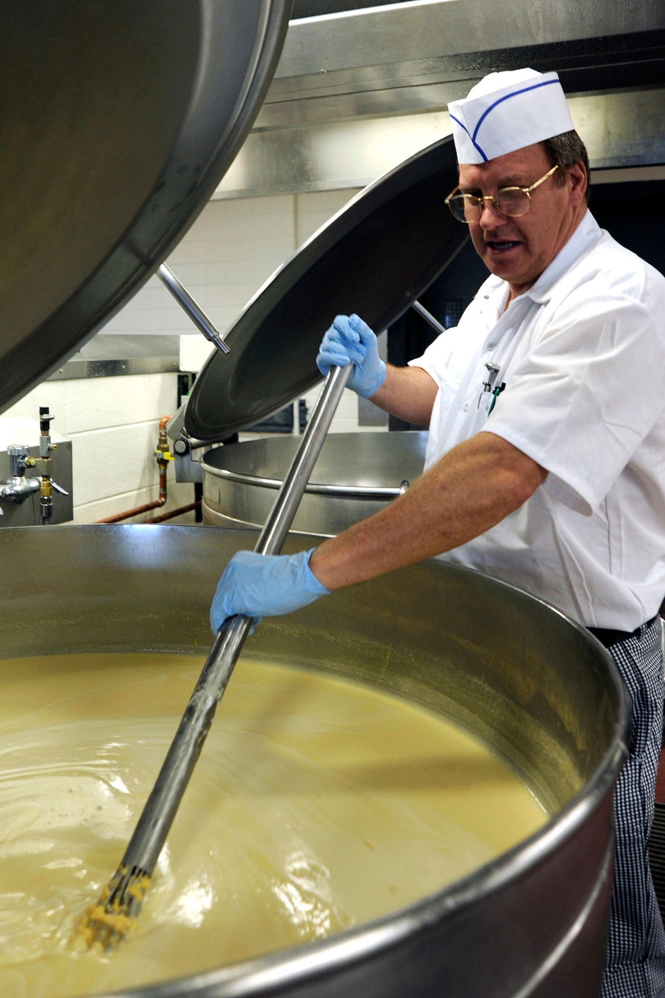 Michael Hoza stirs bubbling vegetables inside the Mitchell Hall dining facility at the U.S. Air Force Academy in Colorado Springs, Colo. The Mitchell Hall staff serves more than 12,000 meals per day for cadets. (U.S. Air Force photo/Dave Ahlschwede)