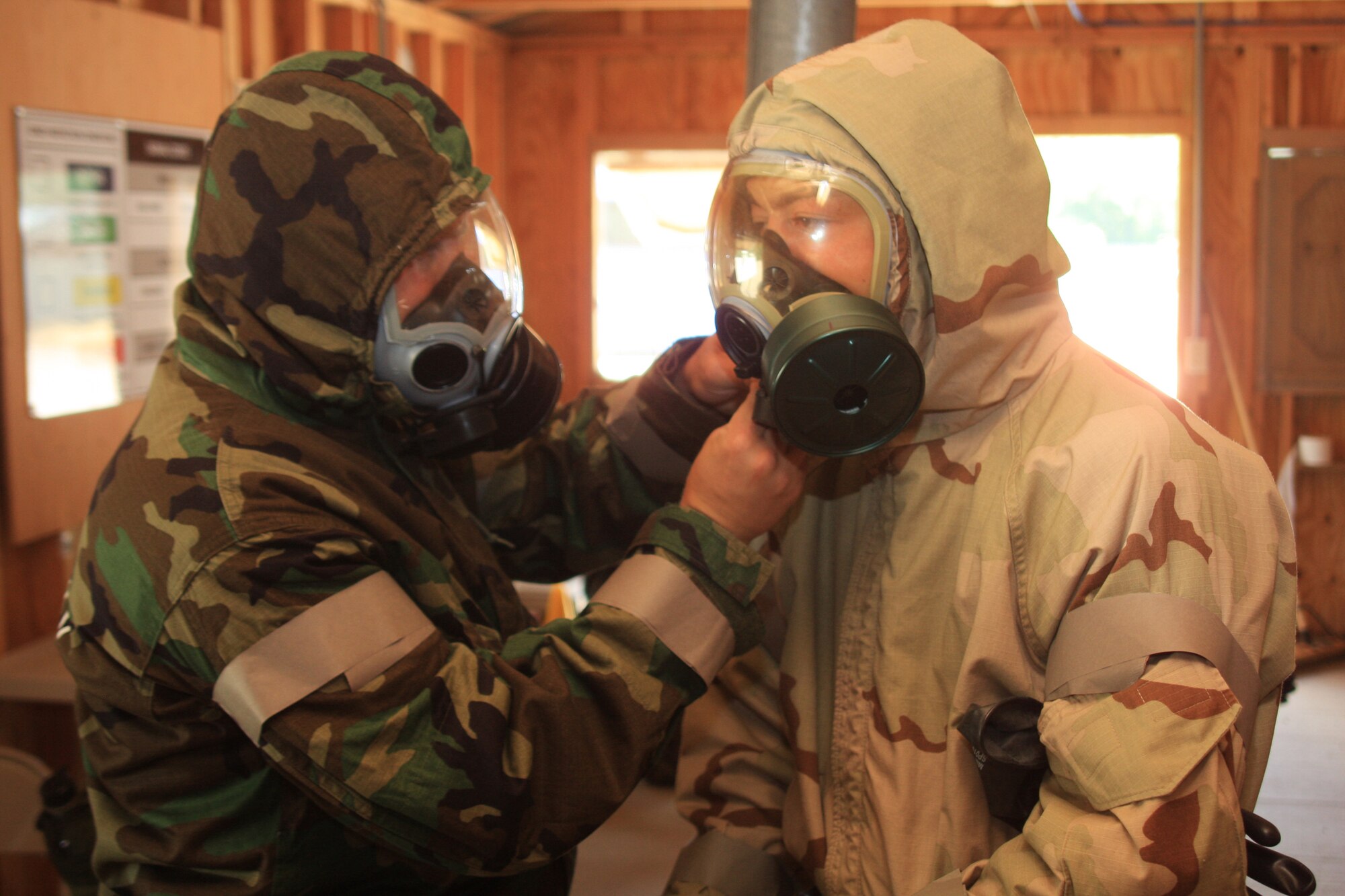 WRIGHT-PATTERSON AIR FORCE BASE, Ohio- Master Sgt. Karl Weitzel (left), 445th Maintenance Operations Flight, helps Chief Master Sgt. William Arehart, Jr., 445th Security Forces Squadron,adjust his protective mask during chemical, biological, radiological, nuclear and high-yield explosive objectives (CBRNE) training July 12. Reservists from the wing are required to attend the training every 20 months. (Air Force photo/Senior Airman Mikhail Berlin)  