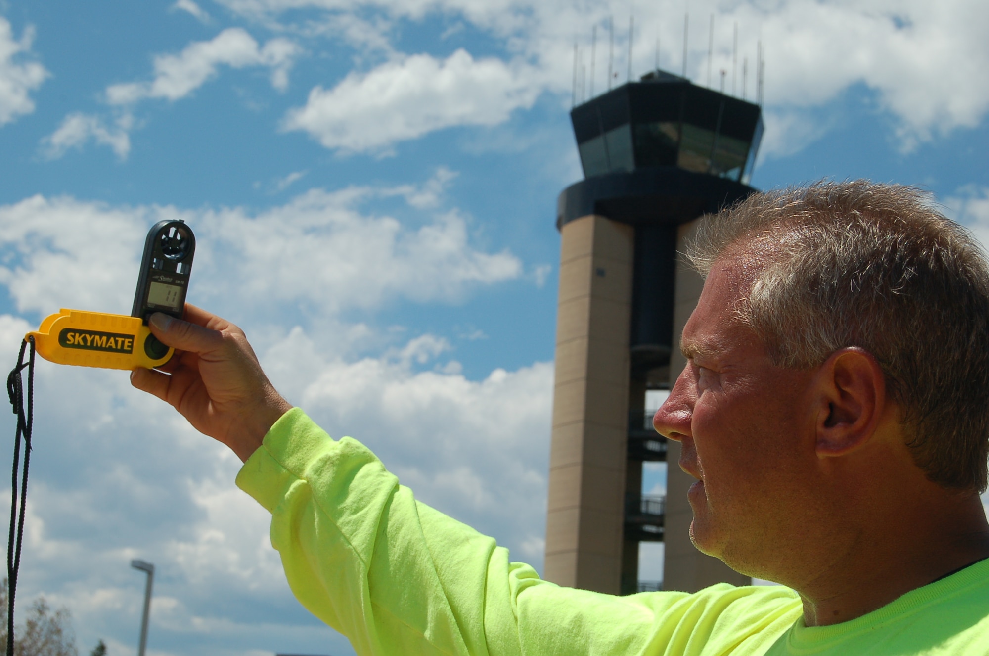 Joe White, Embassy Lawn and Landscaping Inc. pest controller, measures the wind speed near the FAA control tower July 1. The landscaping company purchased three Speed Tech Skymate SM-8 Windmeters that measure wind speed, to prevent herbicides from drifting and possibly harming personnel and vegetation. Staff will not spray herbicides when the wind speed is more than 7 mph. (Air Force photo by Thea Skinner)