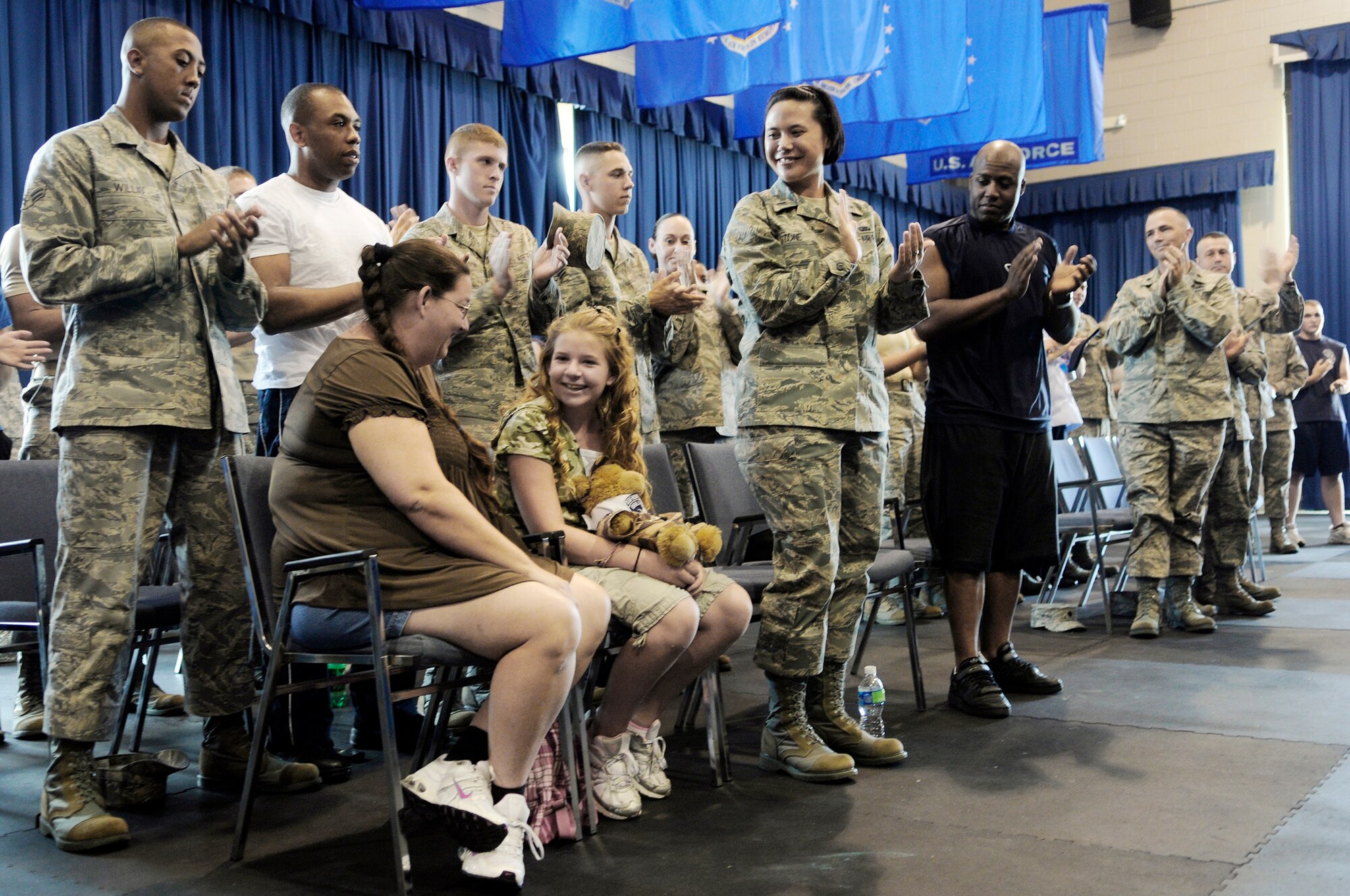 Bailey Reese, founder and president of the nonprofit organization Hero Hugs, and her mother, Diana, receive a standing ovation from members of the Air Force Honor Guard and the 11th Wing July 7 at Bolling Air Force Base, D.C. Bailey first met the drill team at Dobbins Air Reserve Base, Ga., during one of the team's performances and was invited to visit the drill team at Bolling AFB. (U.S. Air Force photo/Staff Sgt. Dan DeCook) 