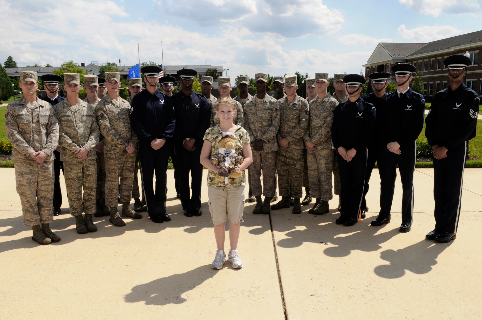 Bailey Reese, founder and president of the nonprofit organization Hero Hugs, poses for a photo with members of the Air Force Honor Guard drill team during a July 7 visit to Bolling Air Force Base, D.C. Bailey started Hero Hugs as a way to say "thank you" to military servicemembers around the world. (U.S. Air Force photo/Staff Sgt. Dan DeCook) 