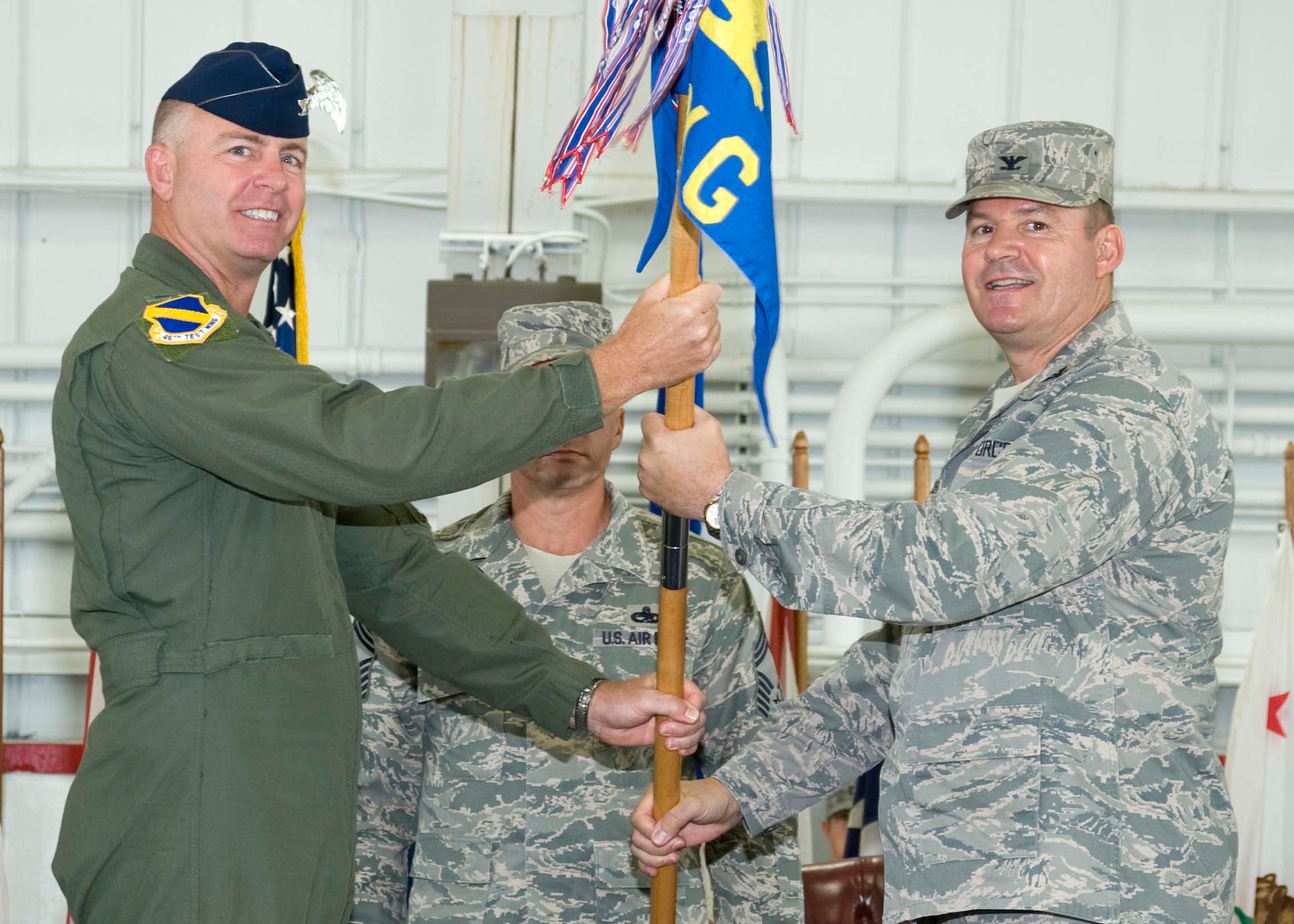 Col. Glenn Ferguson, takes the guidon of the 46th Maintenance Group July 10 as he accepted command from Col. Gary Plumb, 46th Test Wing commander.  Colonel Ferguson takes control of the unit from Col. Nancy Kunkel who retired the same day.  (U.S. Air Force photo/Bruce Hoffman)