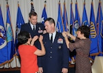 Brig. Gen. Scott Bethel (center), Air Education and Training Command Deputy Director of Intelligence, Operations and Nuclear Integration for Technical Training, receives his first star pinned on by his mother, Patricia Bethel (left), and his wife, Laura (right), while Gen. Stephen Lorenz, AETC commander, looks on. Gen. Lorenz officiated at the July 2 ceremony at Randolph Air Force Base. (U.S. Air Force photo by Joel Martinez)