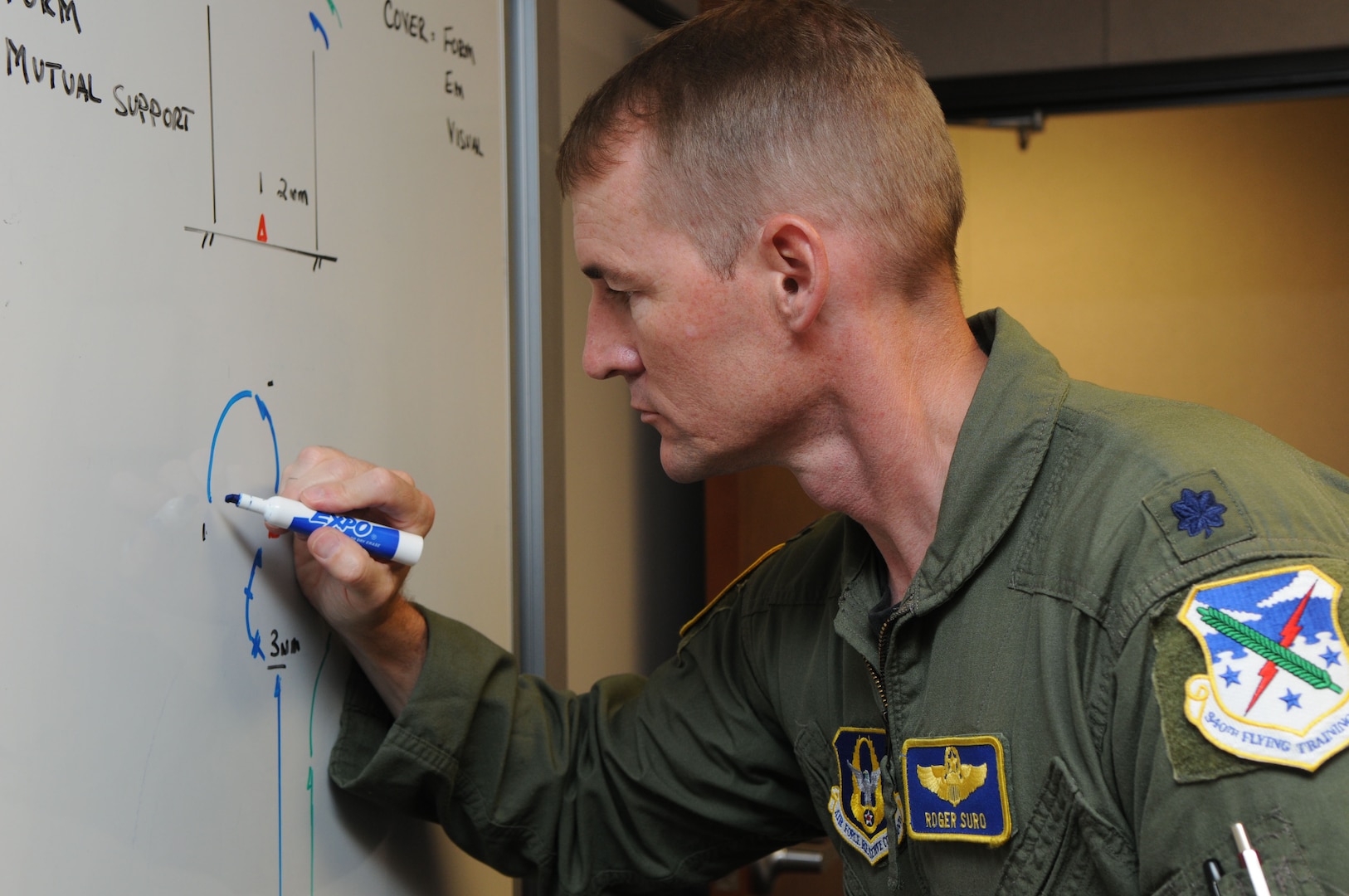 Lt. Col. Roger Suro, a full-time Reserve instructor pilot attached to the 435th Fighter Training Squadron, diagrams a surface tactics sortie on a training room board. (U.S. Air Force photo by Rich McFadden)