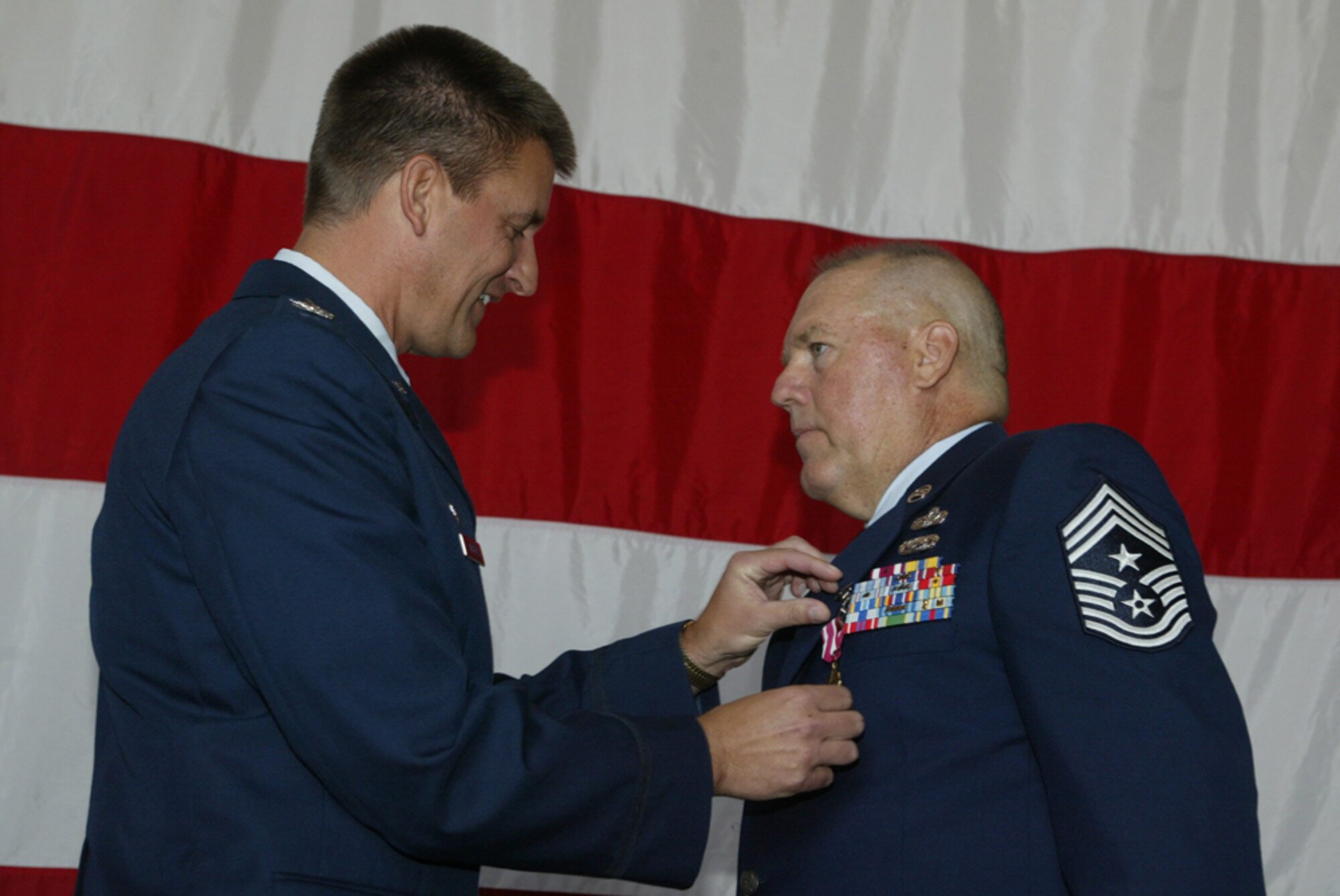 Command Chief Master Sgt. John M. Anderson of the 94th Airlift Wing, receives his Meritorious Service Medal from Colonel Heath J. Nuckolls, commander of the 94th Airlift Wing during the wing commander's call at Dobbins Air Reserve Base on July 11. (U.S. Air Force photo/Don Peek)